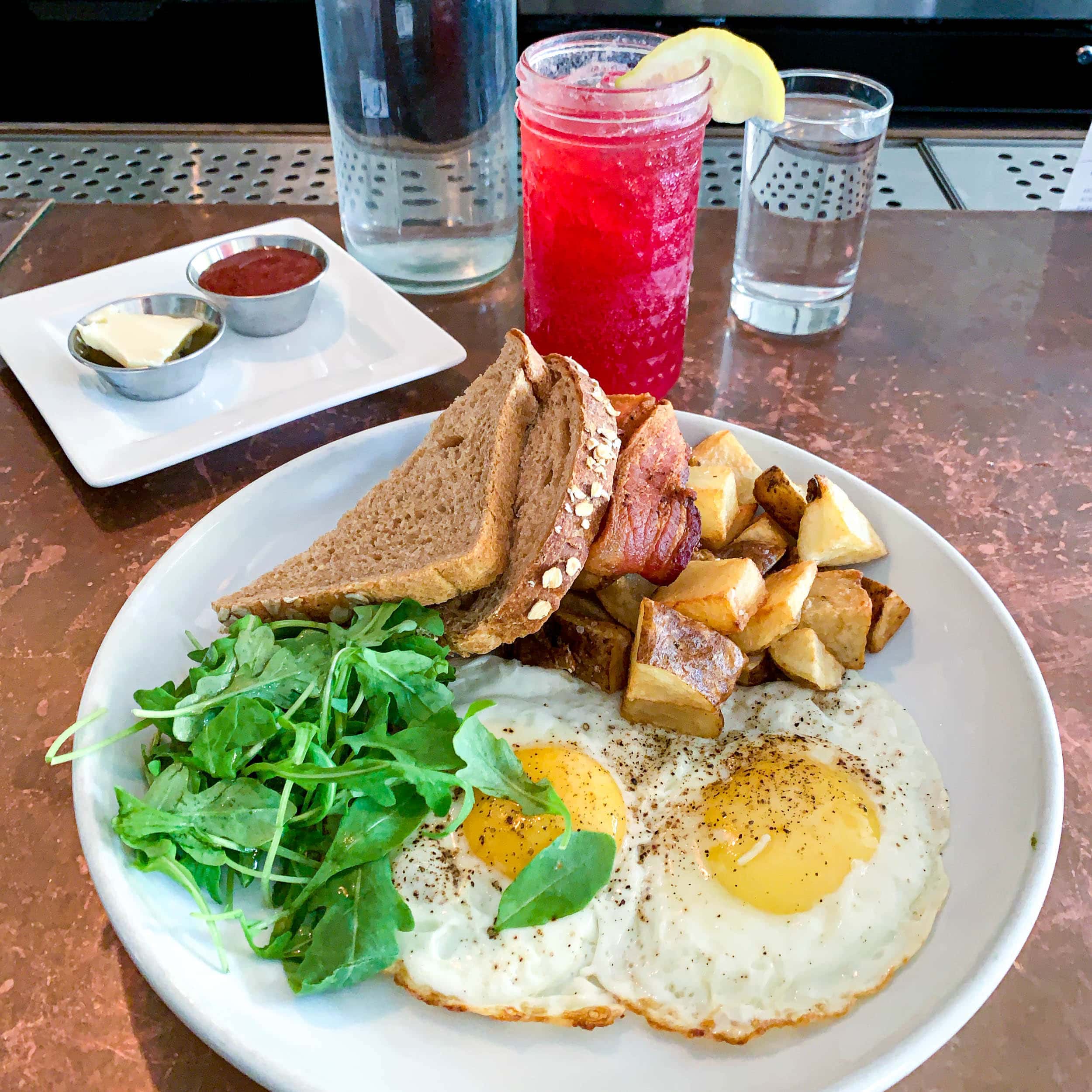 Big Brekkie plate with a hibiscus lemonade vodka cocktail at Hillside Farmacy.