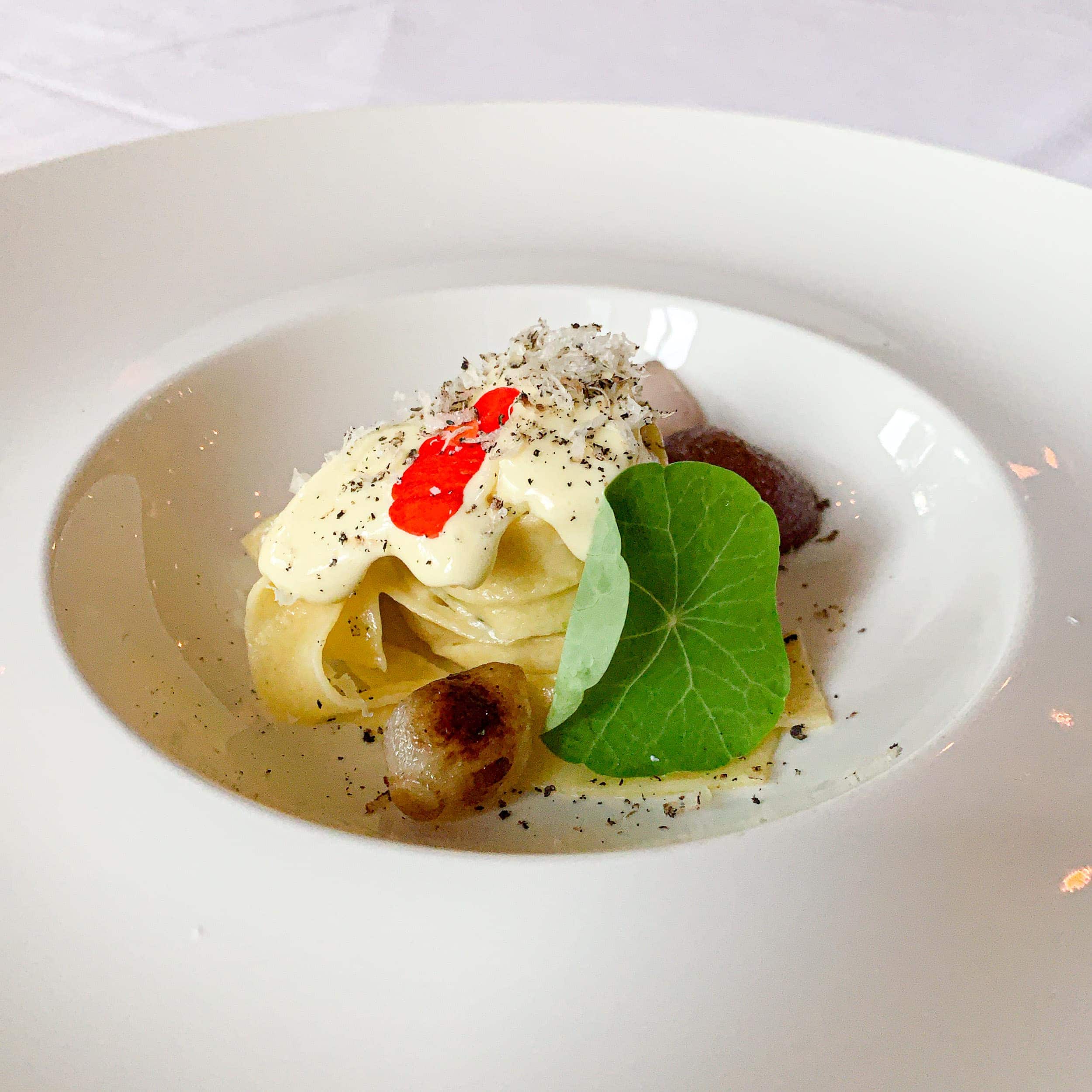 Lovage tagliatelle with pearl onions, green garlic, and hazelnuts