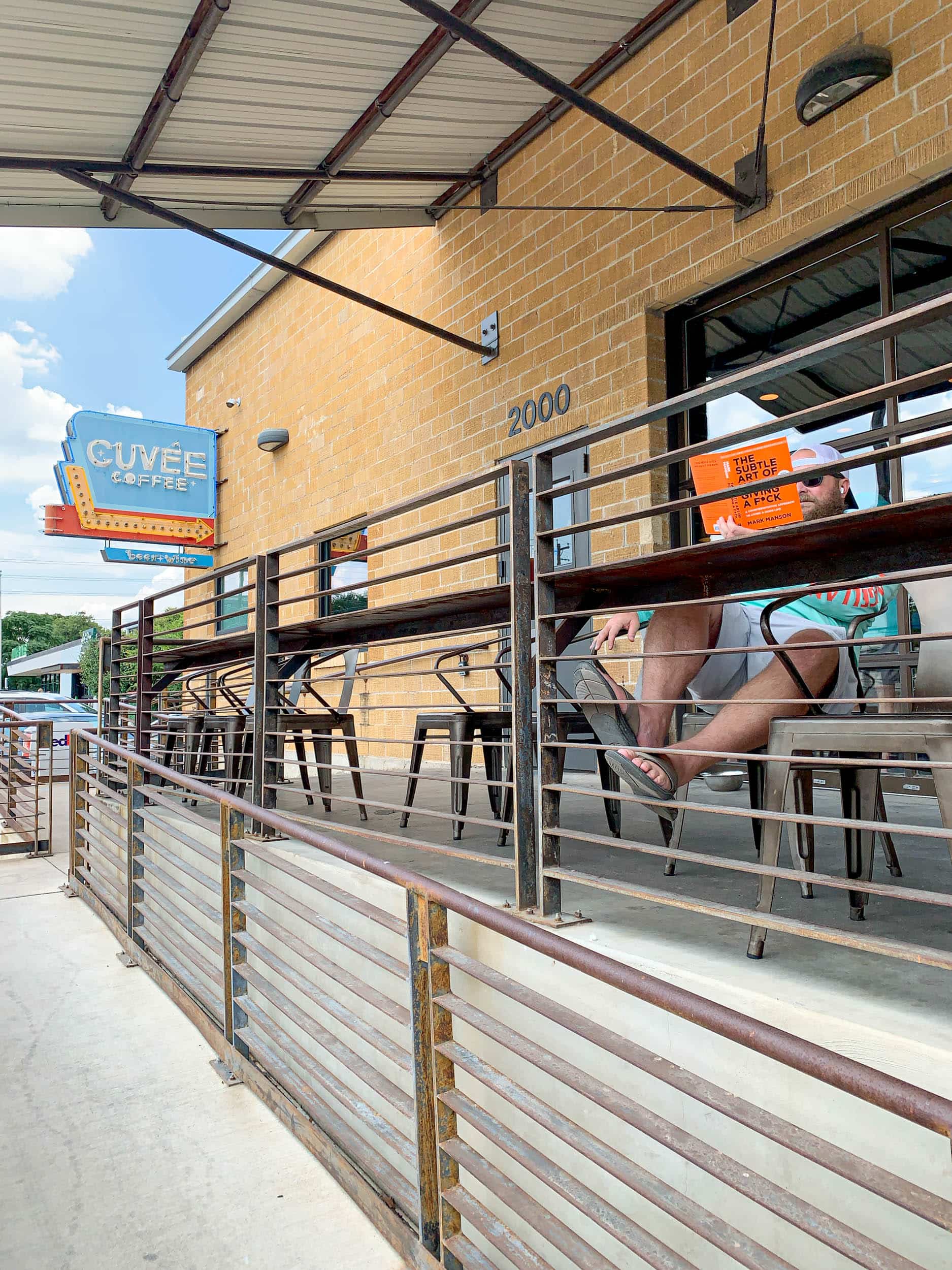 A man reading outside Cuvee Coffee Bar in East Austin.