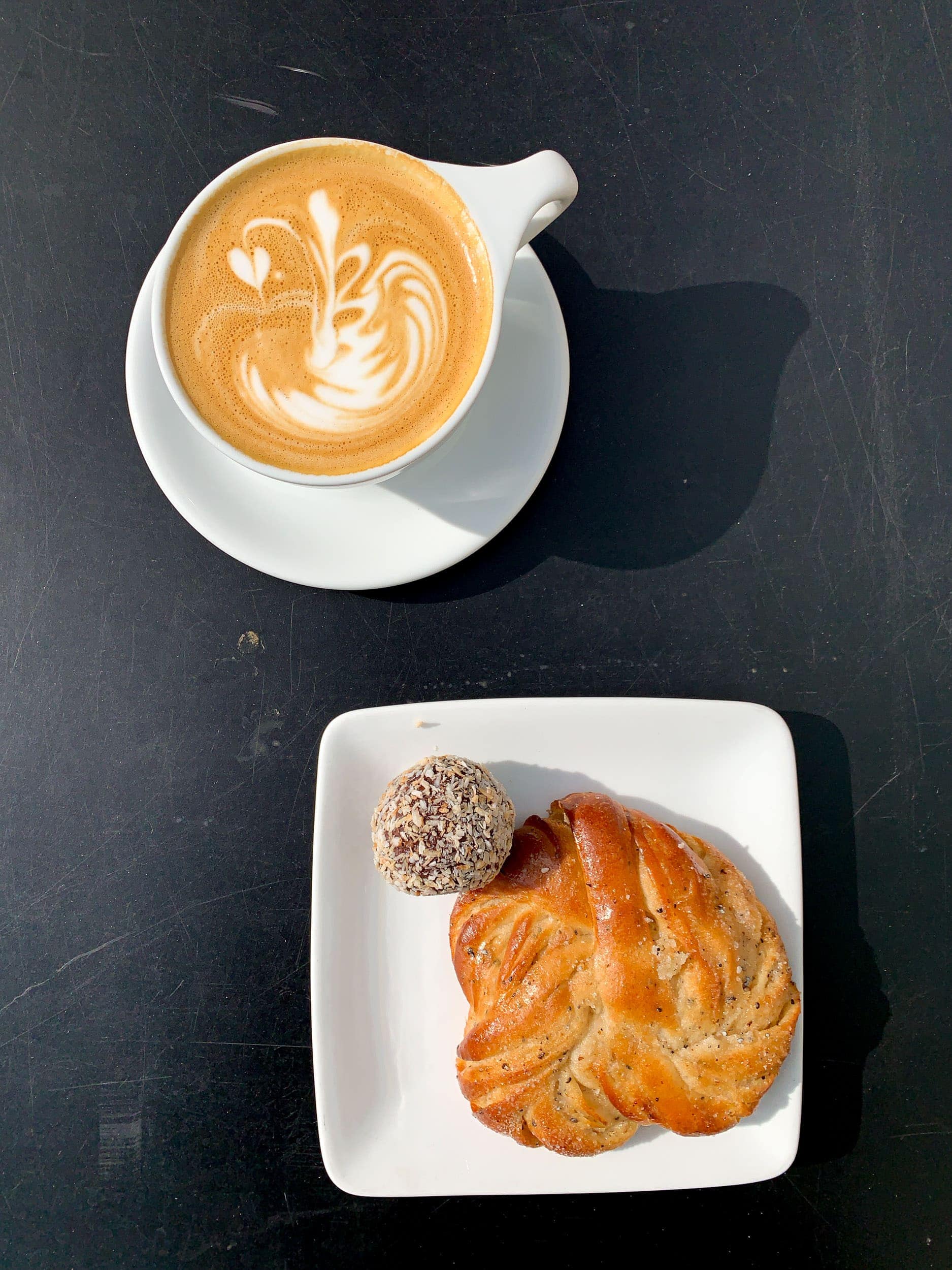 Swedish fika with cappuccino, cardamom bun, and chocolate ball