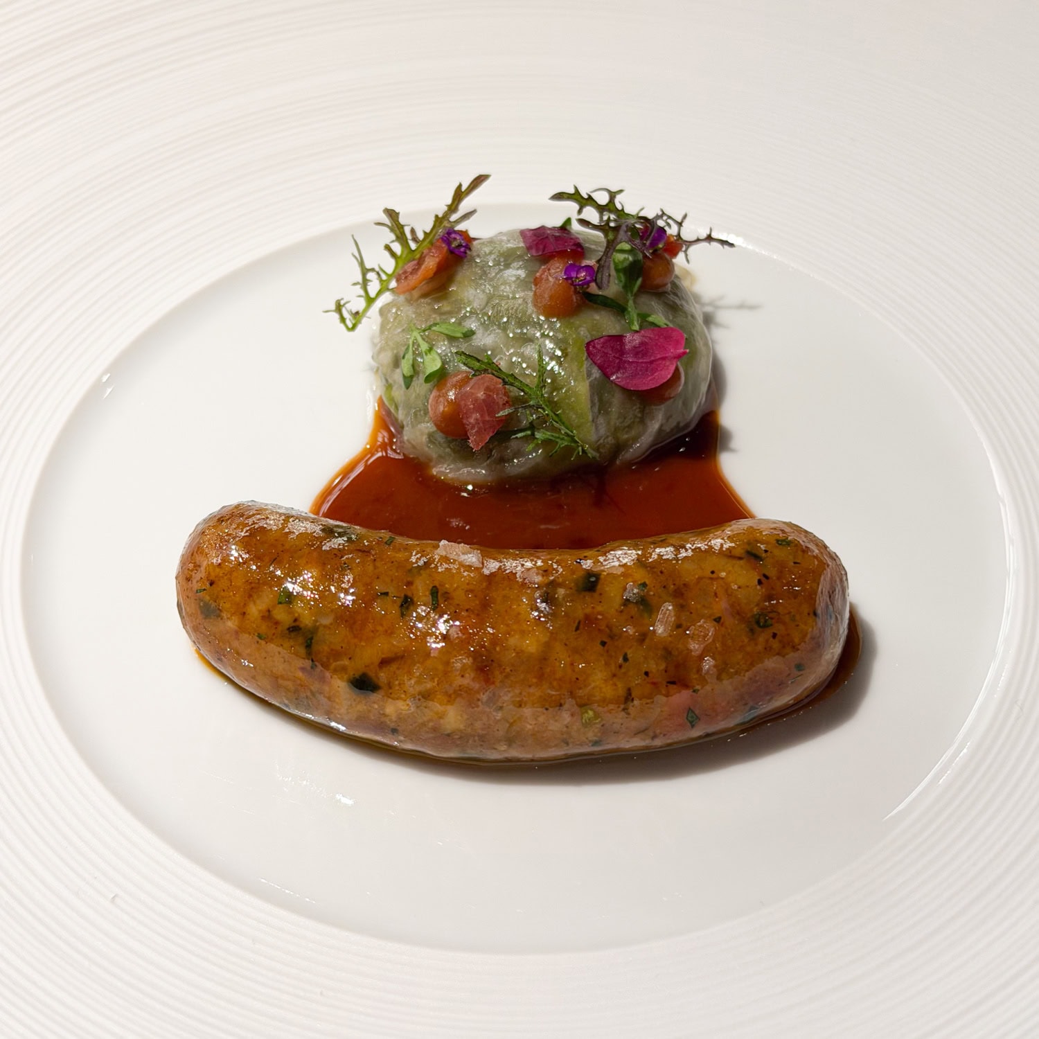 Emeril's boudin with collard greens, hamhock, and Creole jus gras.