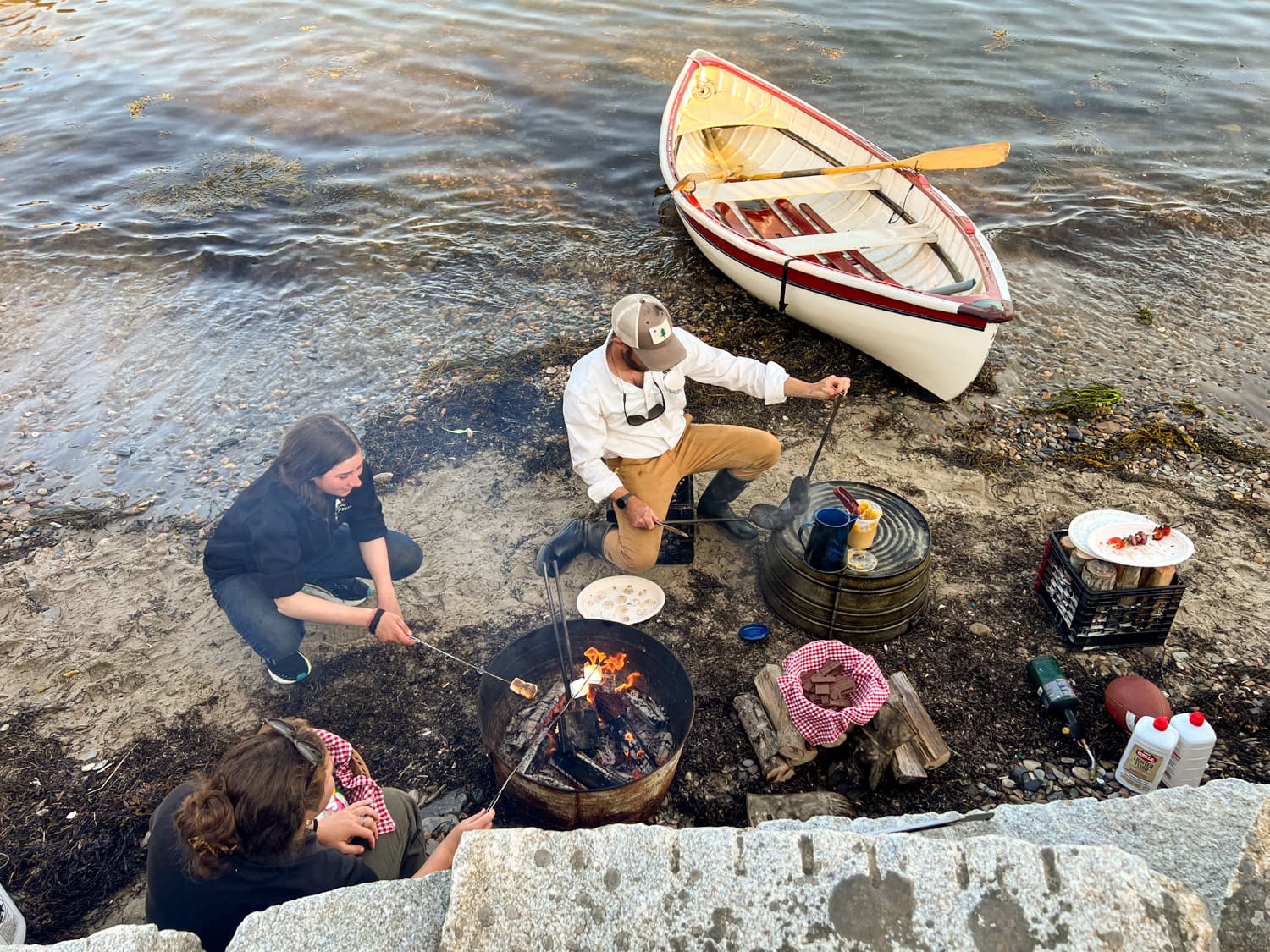 Captain Justin and crew making s'mores on the beach