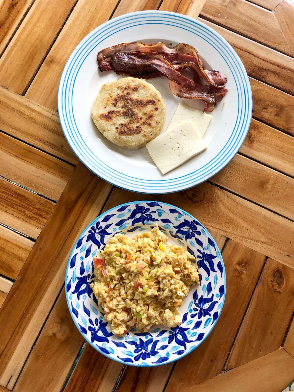 Colombian breakfast: scrambled eggs, bacon, arepa, and cheese