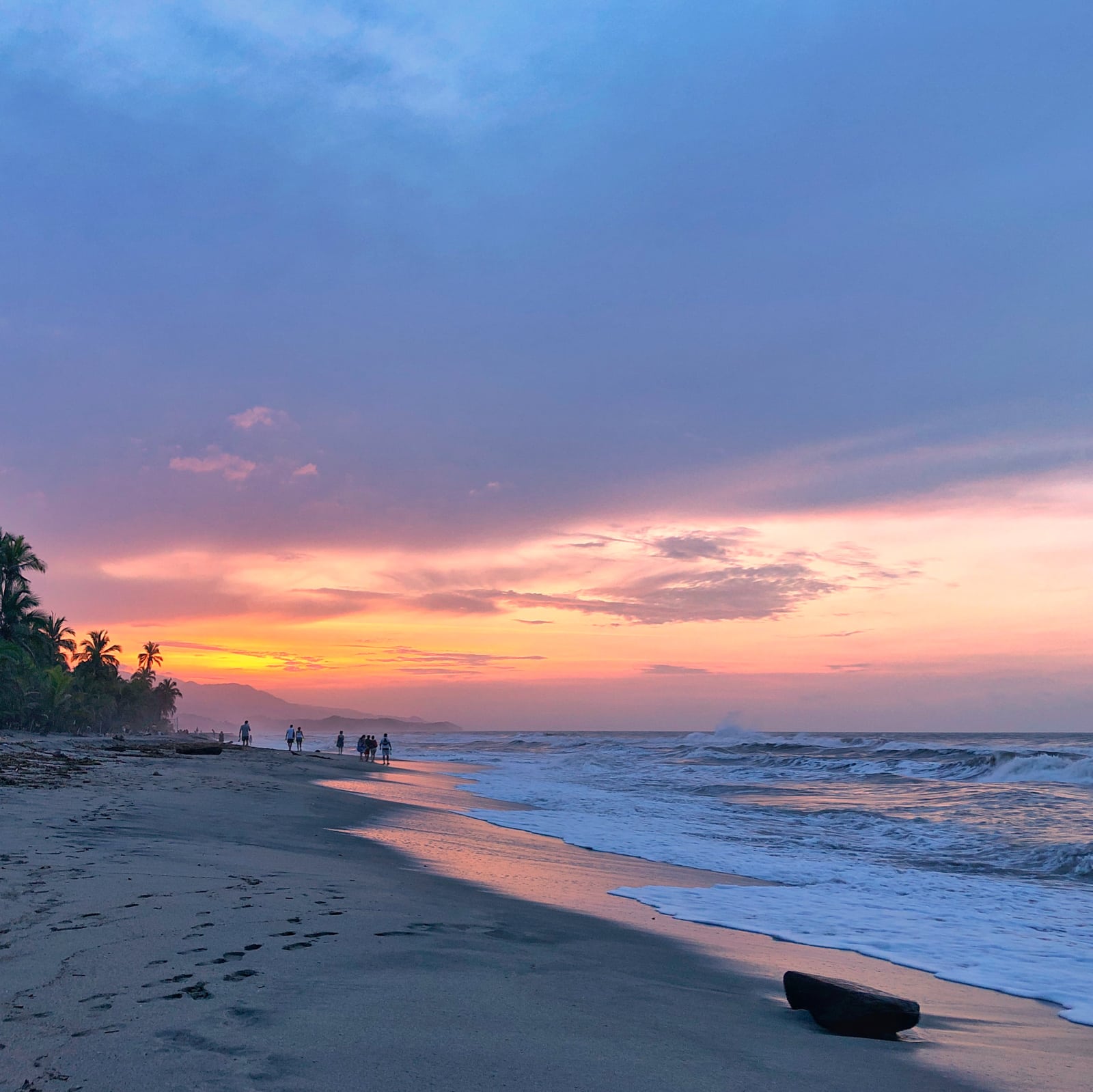 Travelers walking at sunset on Costeño Beach