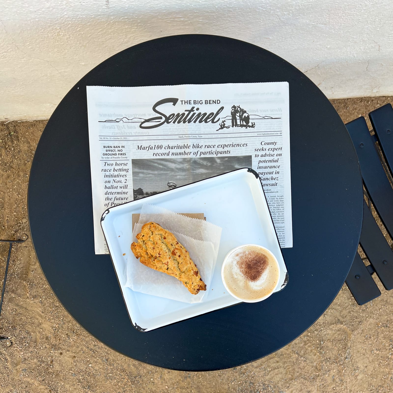 The Sentinel newspaper, a hot drink, and scone