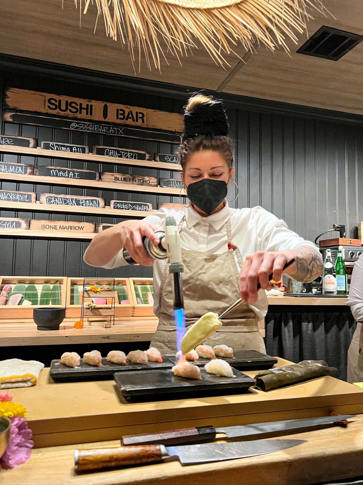 Chef Ambrely Ouimette melts butter over nigiri at Sushi Bar ATX