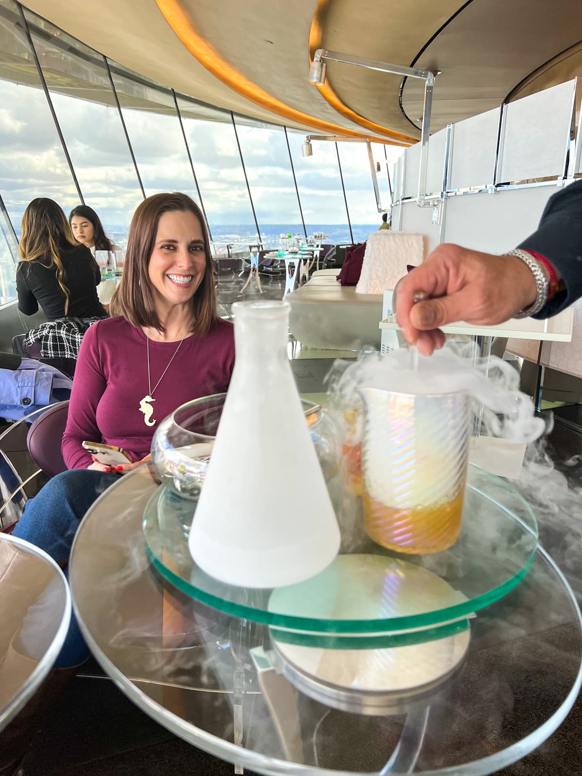 Kel smiling as her cocktail is made tableside in the Loupe Lounge