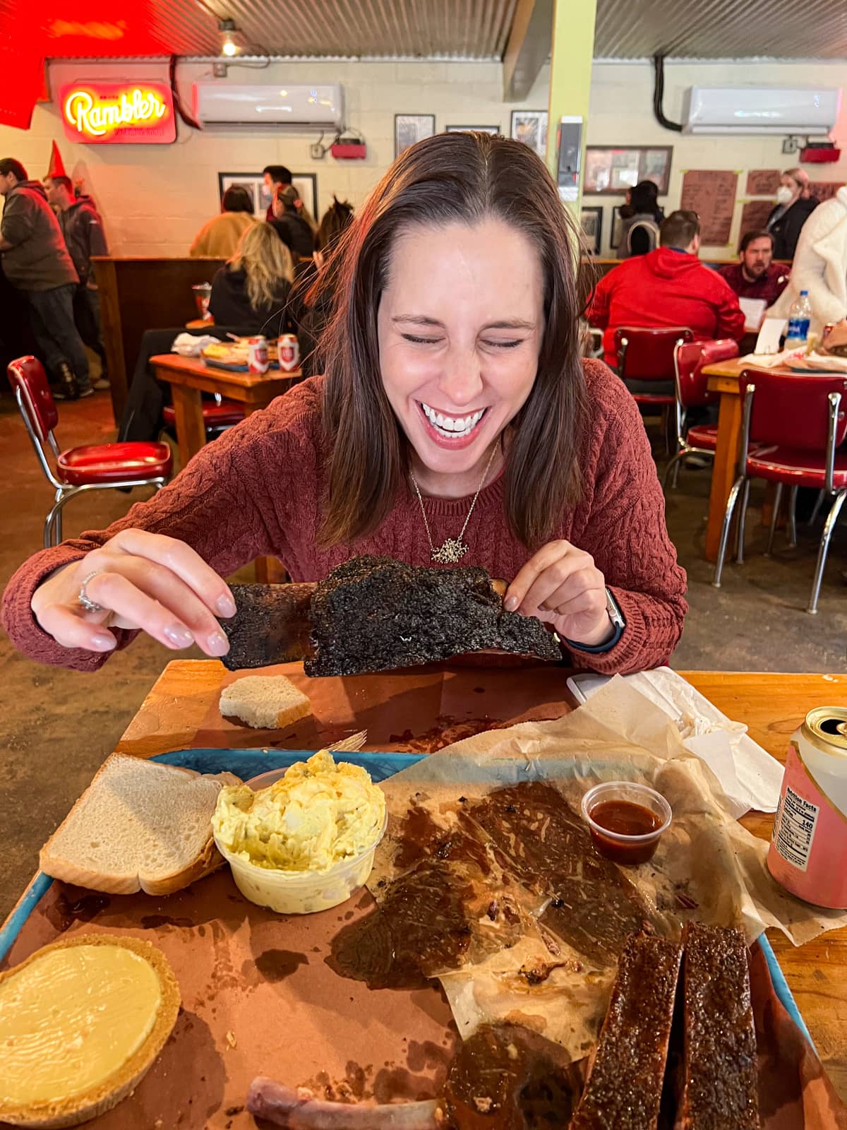 Kel laughing with a big beef rib in her hands