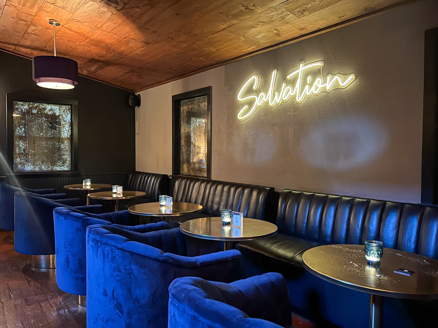 Comfortable blue seating inside The Speakeasy cocktail bar