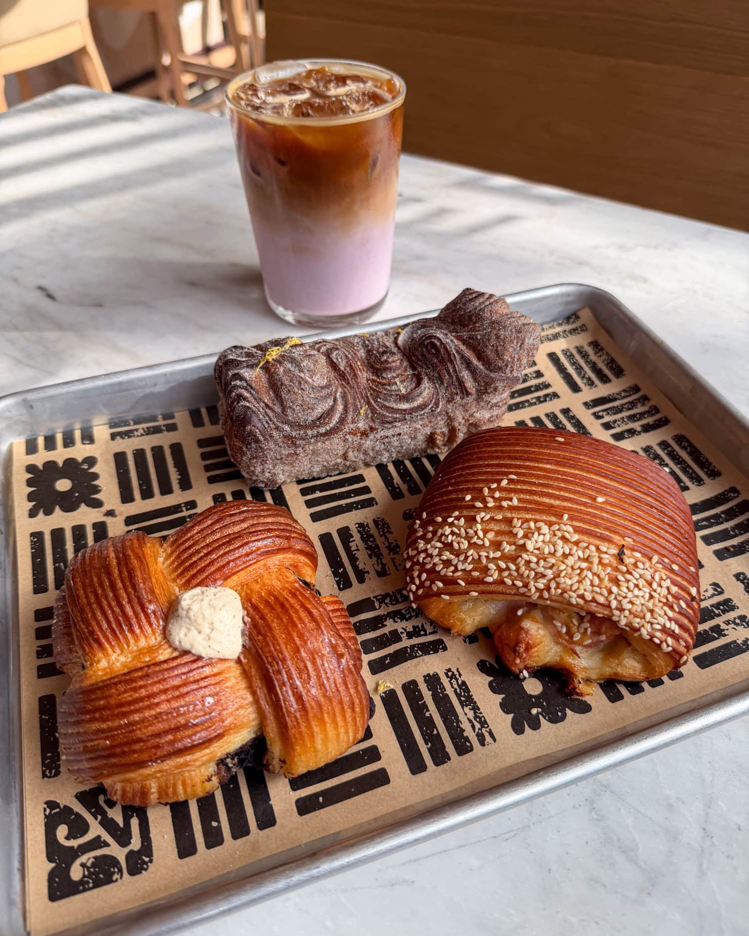 Coffee cube, cardamom pastry, ham and cheese croissant, and smoked raspberry latte at Sugarwolf Bakery in downtown Austin