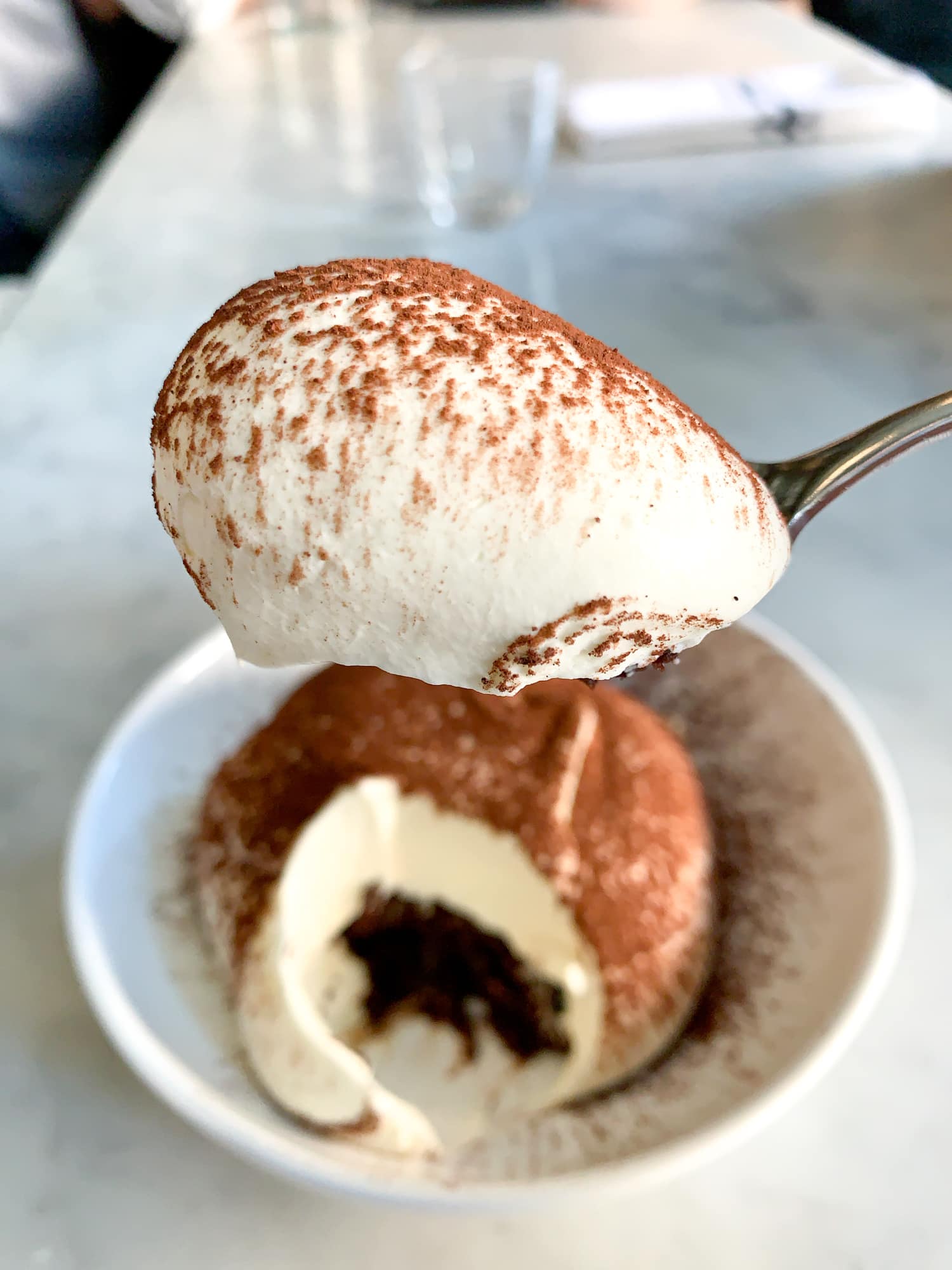 A bite of chocolate cake and whipped cream at Estela NYC