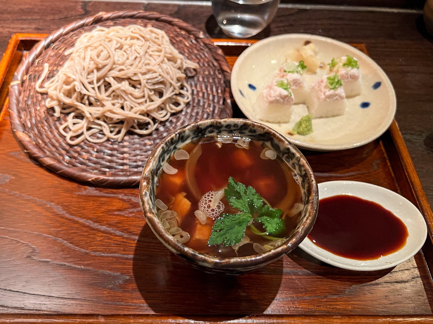 Soy dipping sauce with chicken, soba noodles, and sushi at Tei-An Dallas