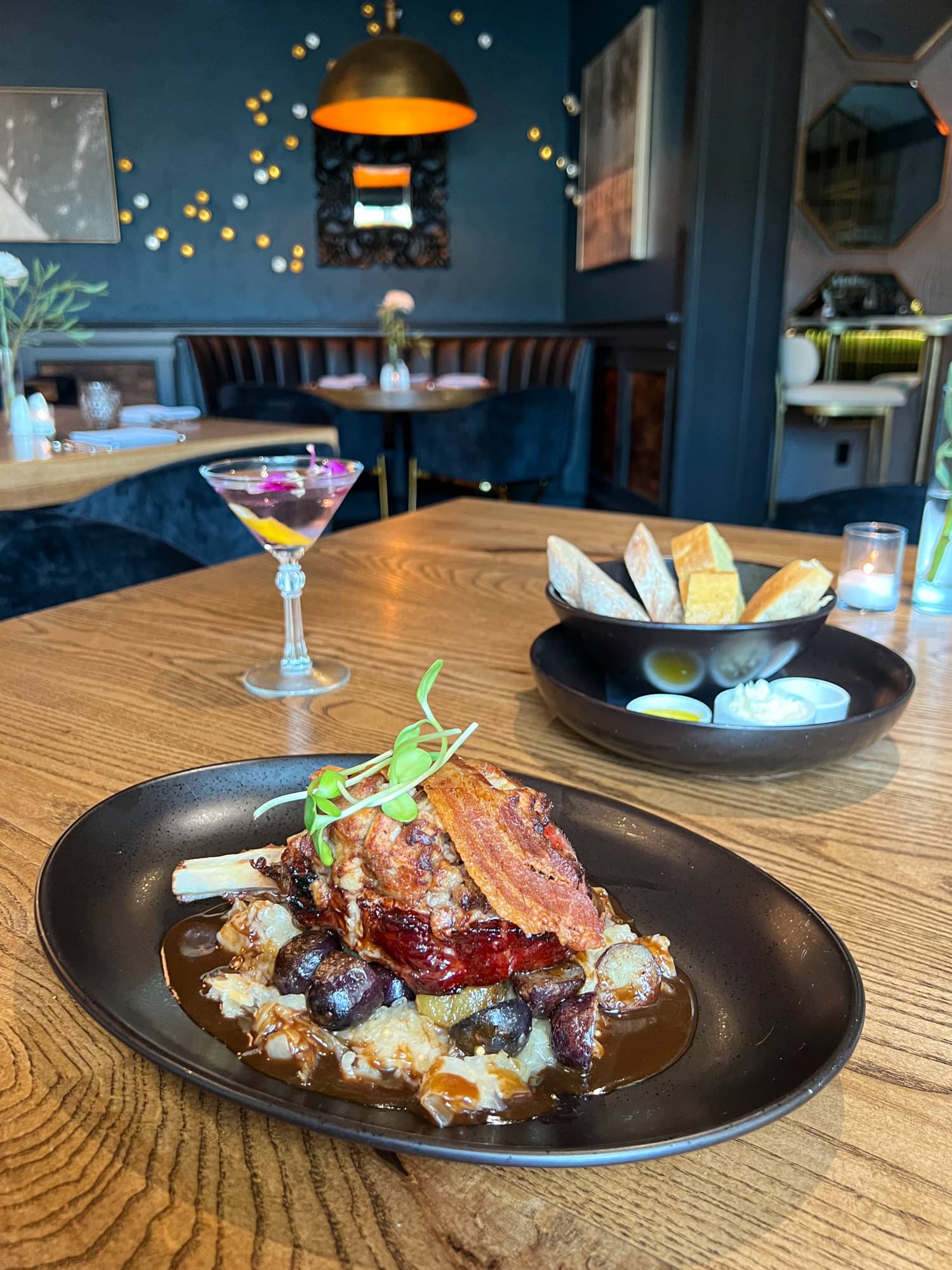 Smoked pork chop with pork belly crumble, apple sauerkraut, black garlic jus, and marble potatoes at Sage Restaurant and Lounge