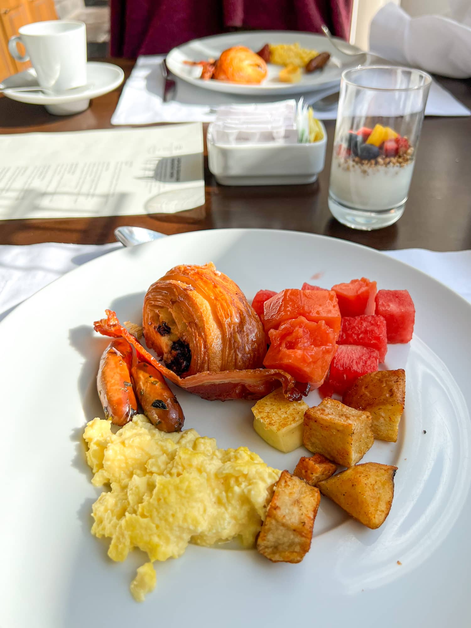 Eggs, fruit, fried cheese, pastry, and parfait from the breakfast buffet