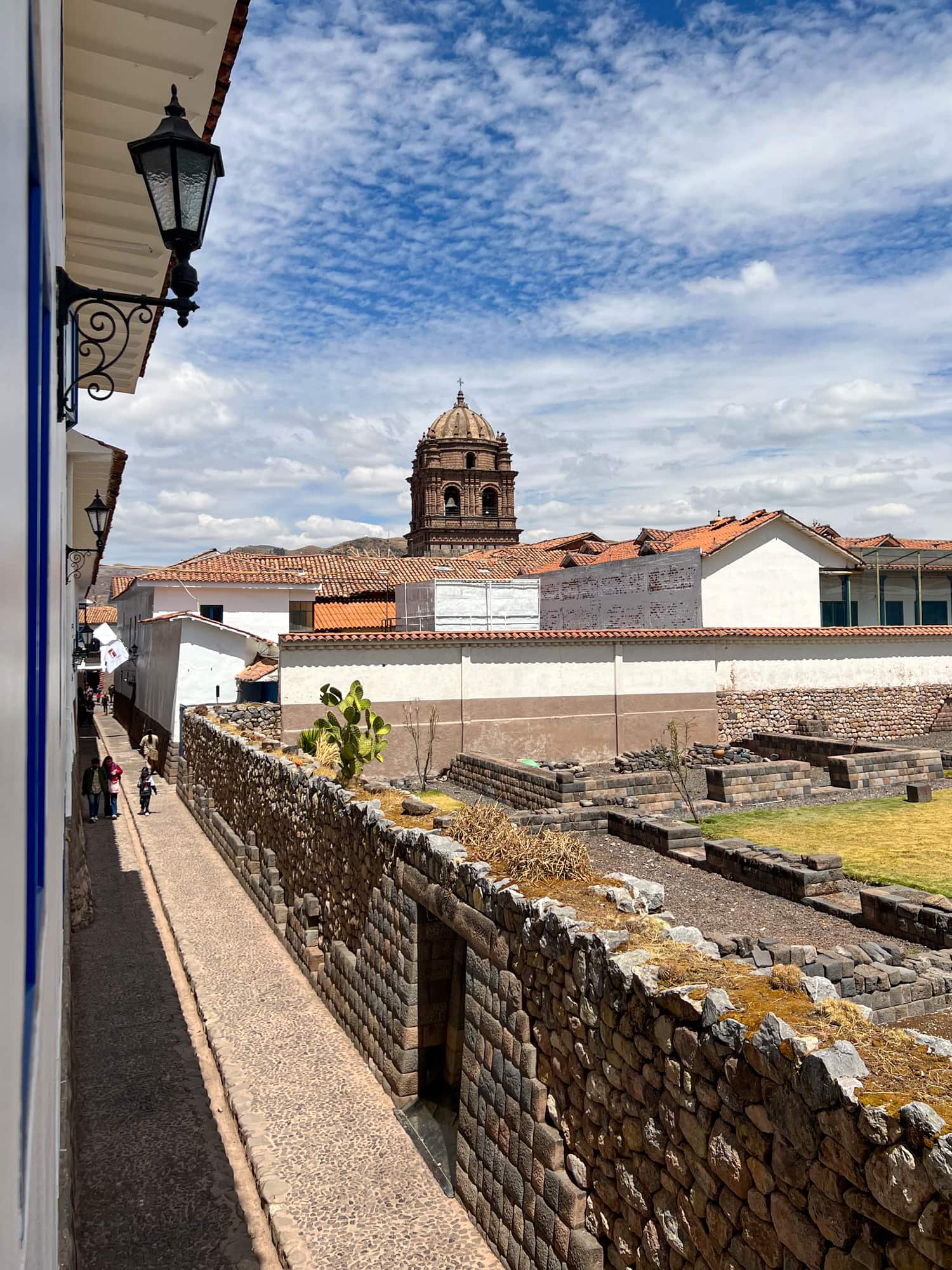 An Inca wall lines a pedestrian alley next to the hotel