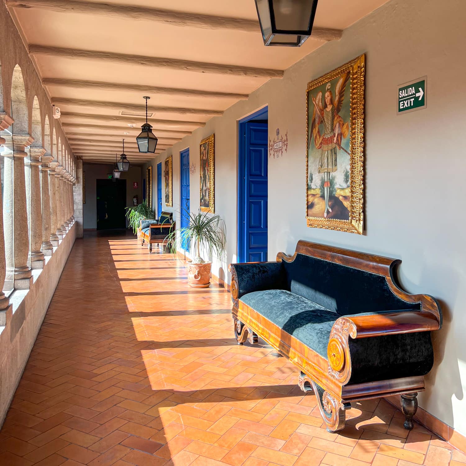 Peruvian paintings line a hallway facing the inner courtyard at Palacio del Inka