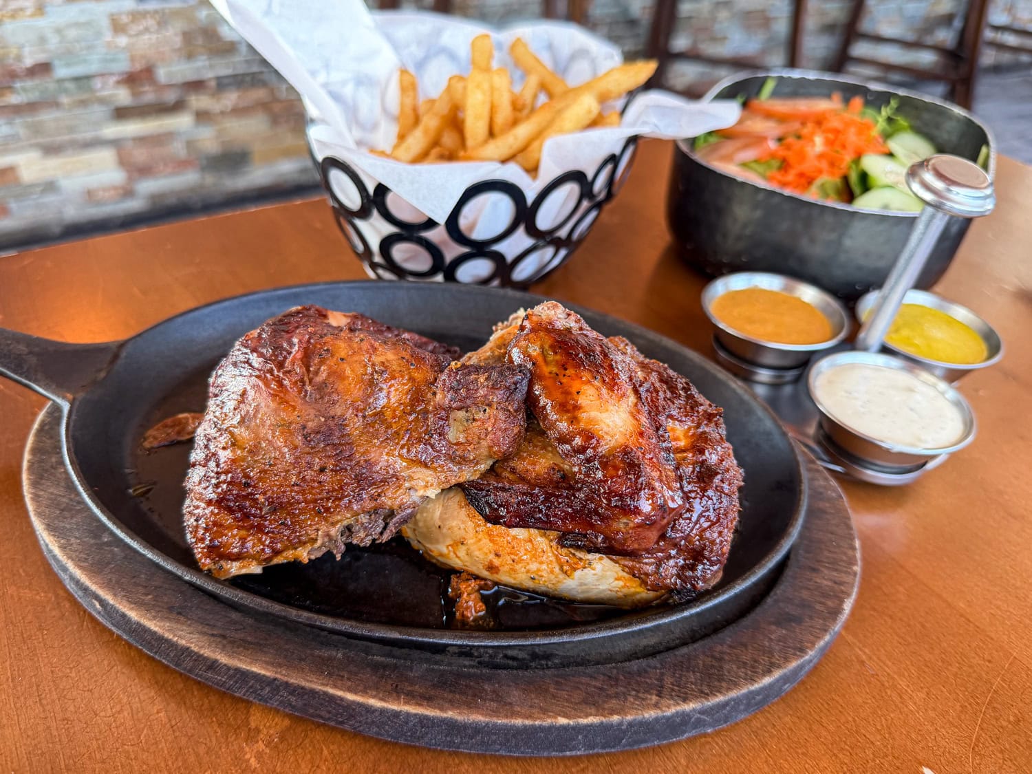 Peruvian pollo a la brasa roasted chicken with fries, salad and dipping sauces (aji, rocoto, and mayo).