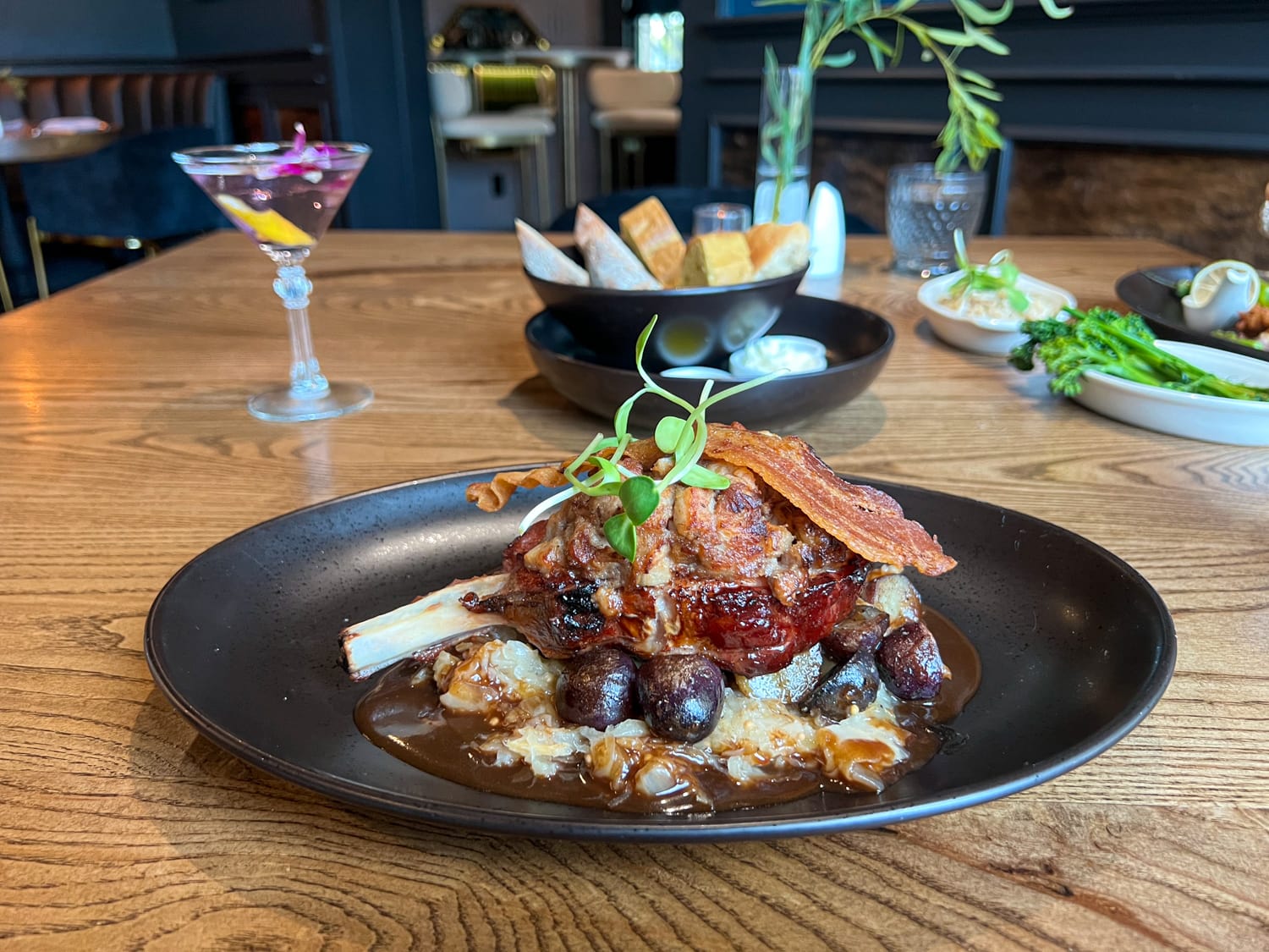 Smoked pork chop with with pork belly crumble, apple sauerkraut, black garlic jus, and marble potatoes at Sage in Fredericksburg, TX