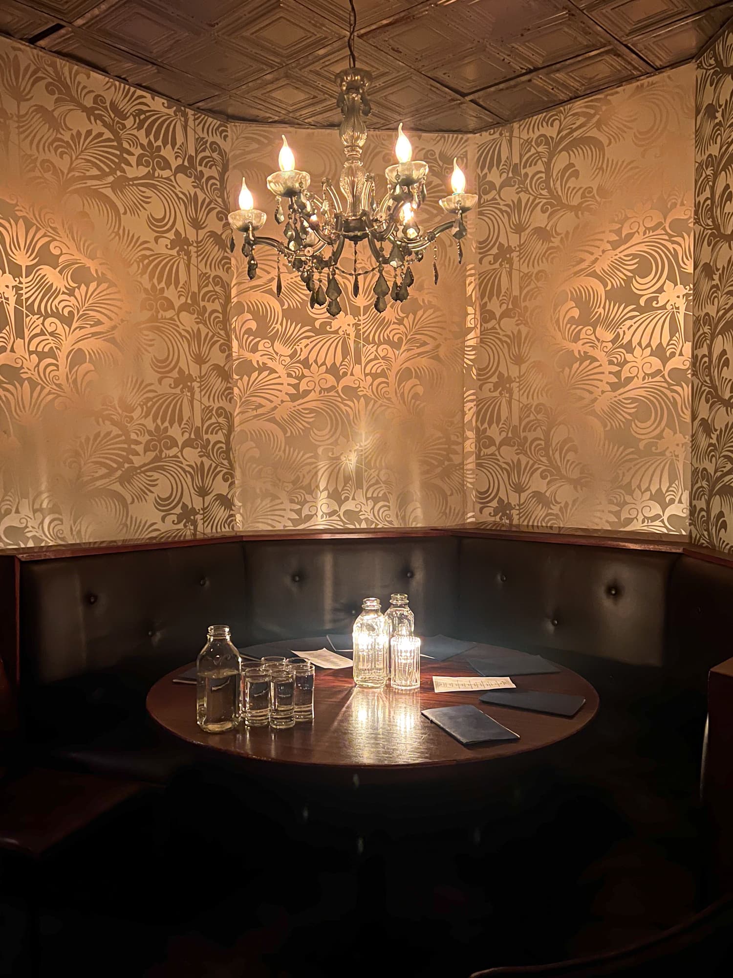 A table and gold wallpaper at The Patterson House in Nashville