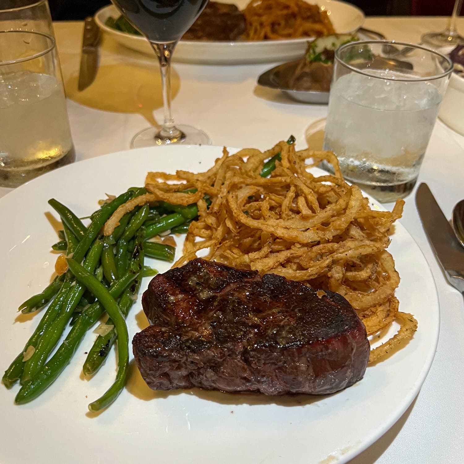 Filet mignon, onion rings, and string beans at Bern's Steak House, one of the best places to eat in Tampa, FL