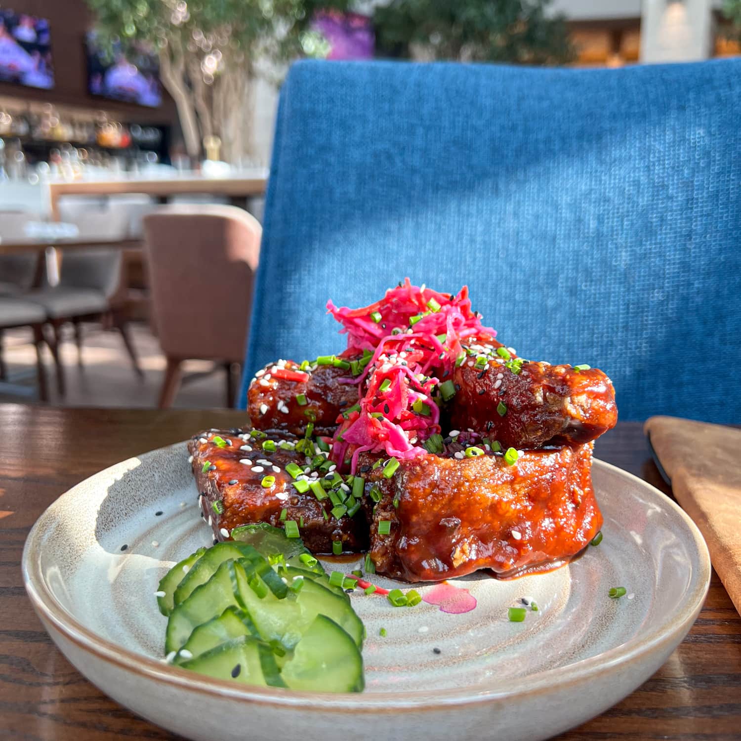 Glazed pork riblets with cured cucumber, sesame seeds, and pickled cherry and hoisin glaze