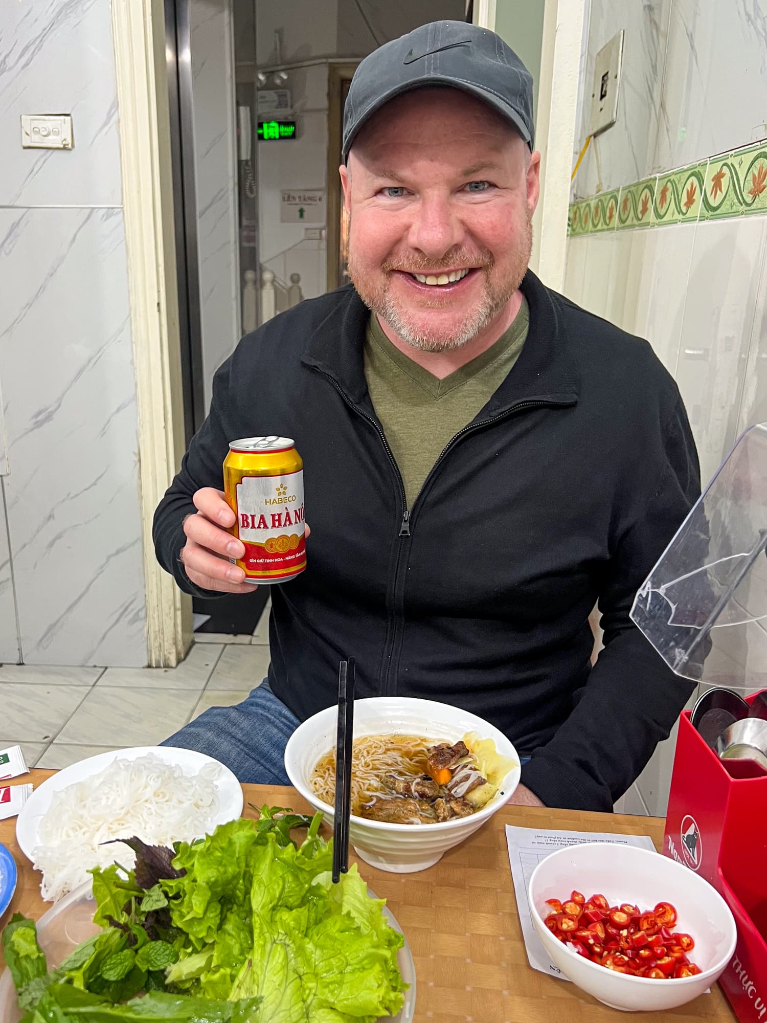 Dave eating bun cha with a Vietnamese beer in Hanoi