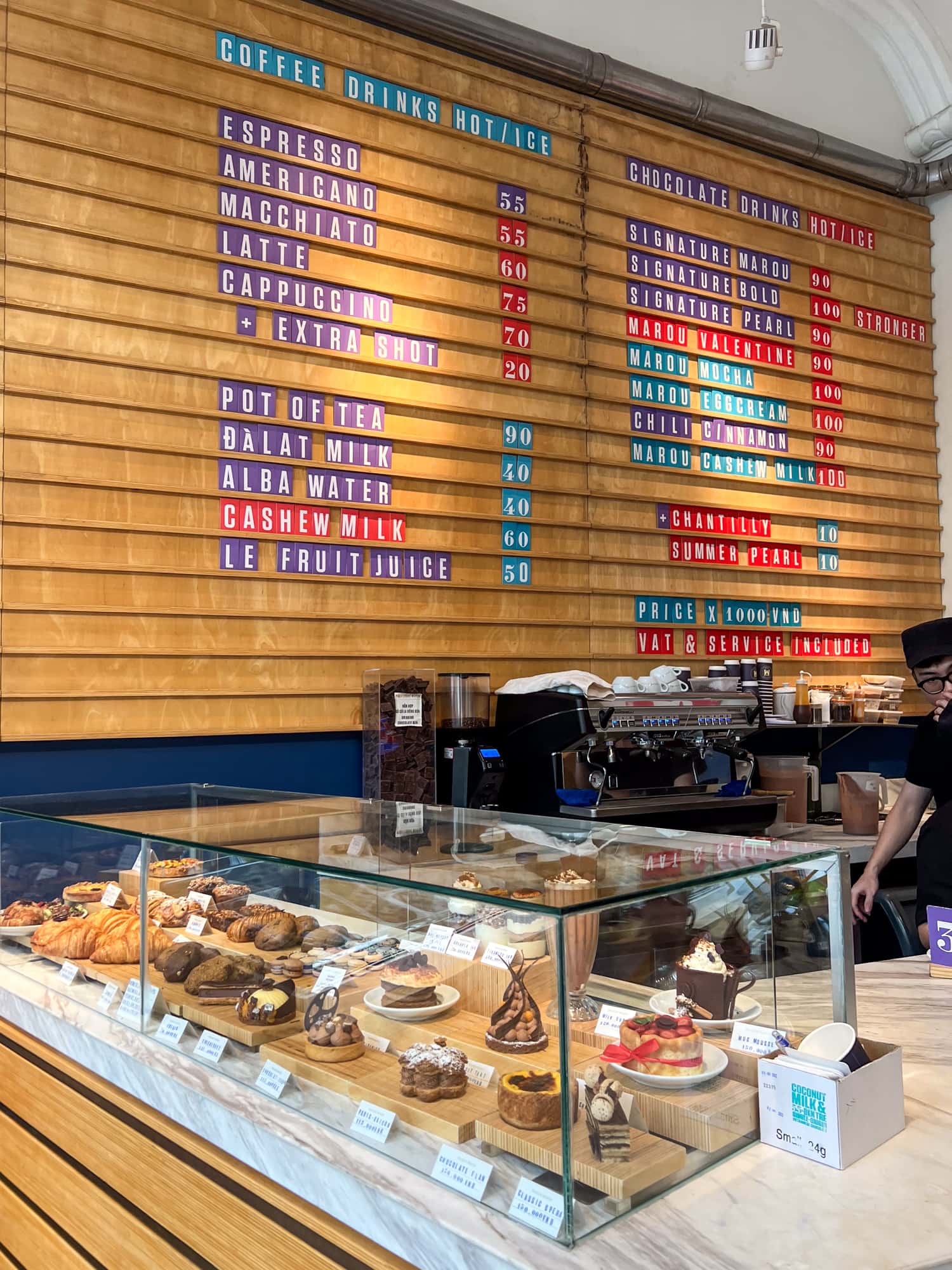 Coffee menu and pastry display at Maison Marou's flagship location in Hanoi