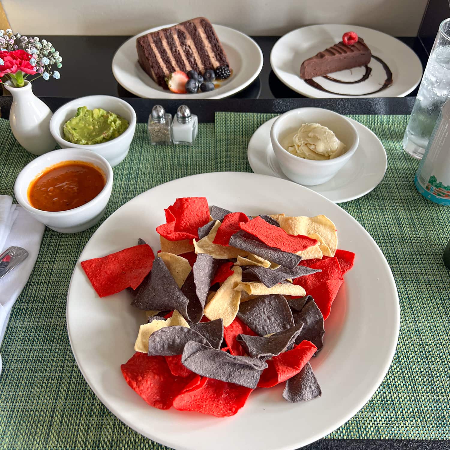 Room service at The St. Anthony Hotel: chips and salsa, guacamole, chocolate mousse cake, and a chocolate torte with vanilla ice cream