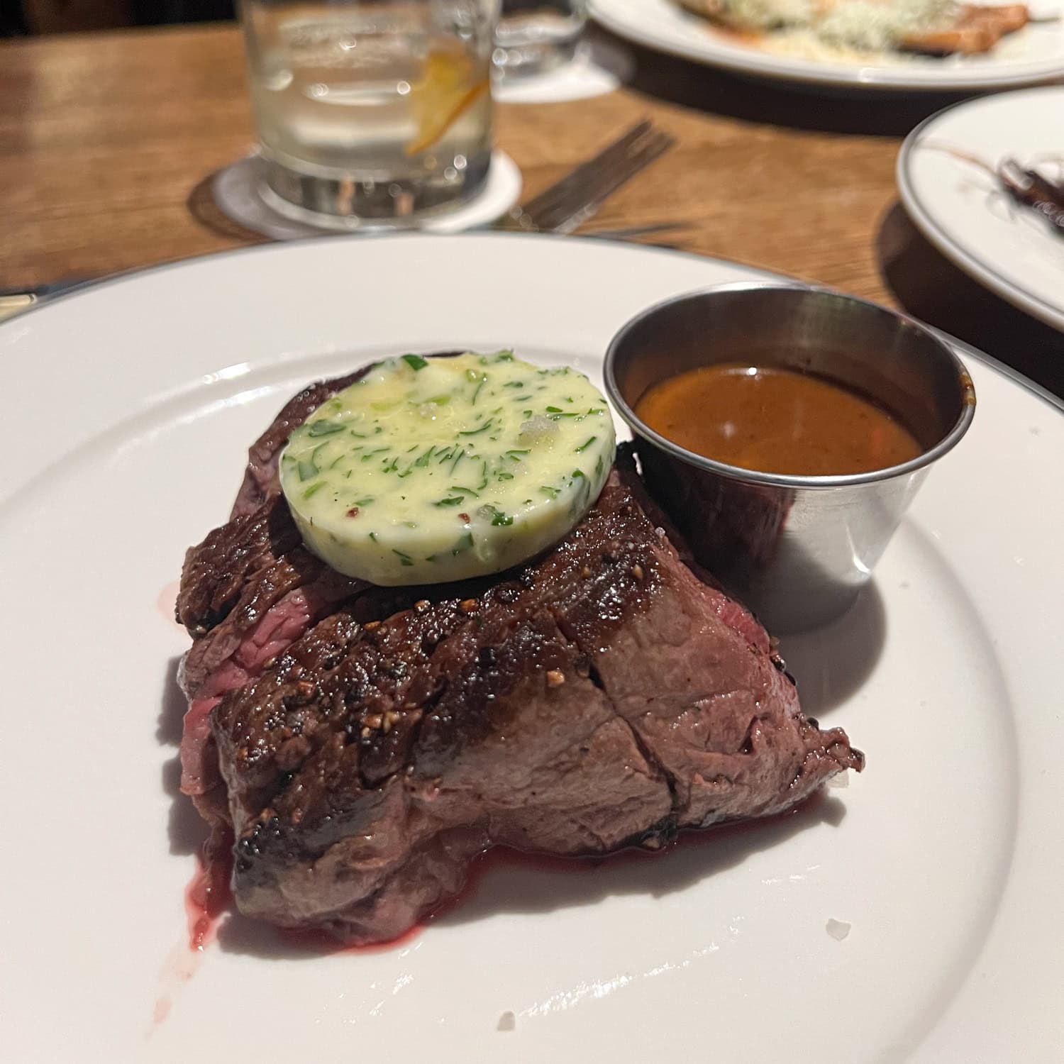 8-ounce filet mignon with herbed butter and au poivre sauce on the side.