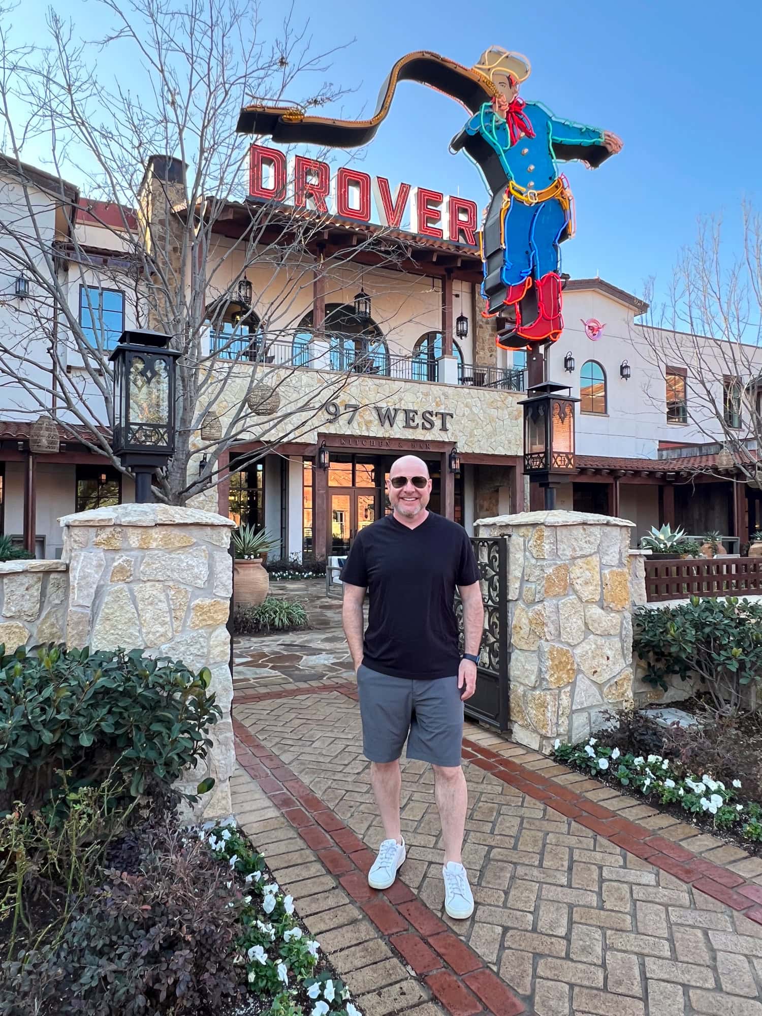 Dave stands under a neon cowboy by Evan Voyles at Hotel Drover in the Fort Worth Stockyards (photo by Kelly Lemons).