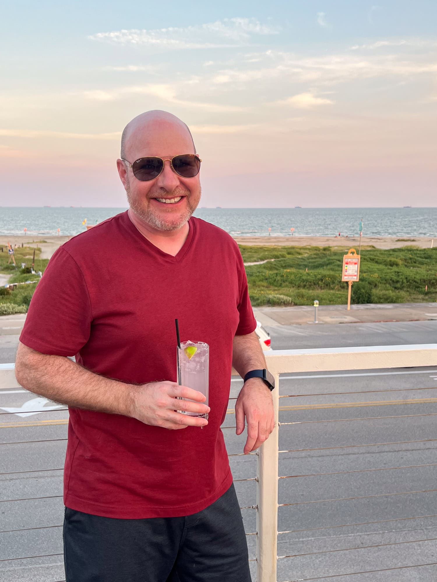 The author holding a Laco coconut ranch water at sunset with Galveston Island beach in the background (photo by Kelly Lemons).