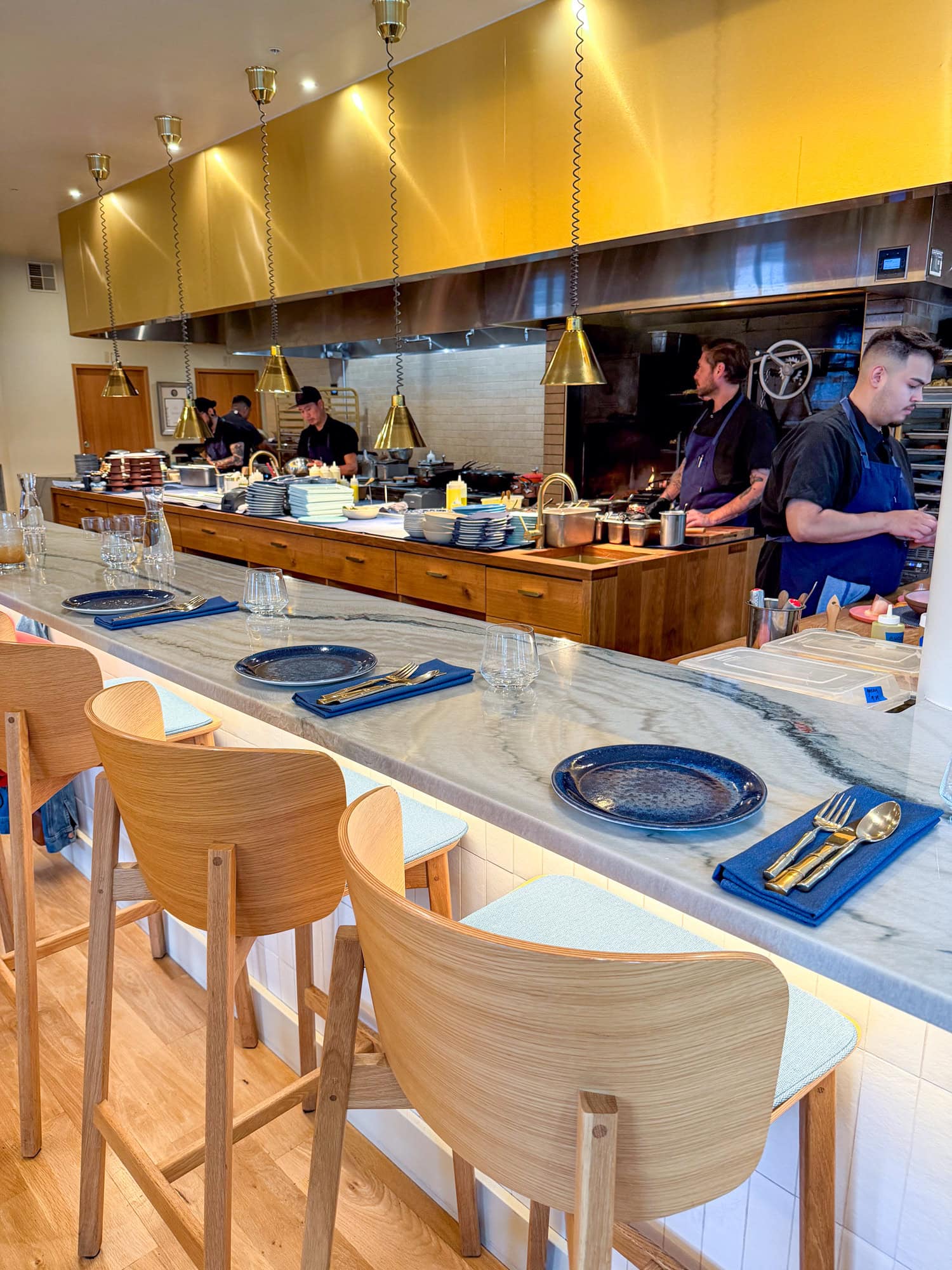 Counter seating looks into an open kitchen at Kann restaurant in Portland, Oregon.