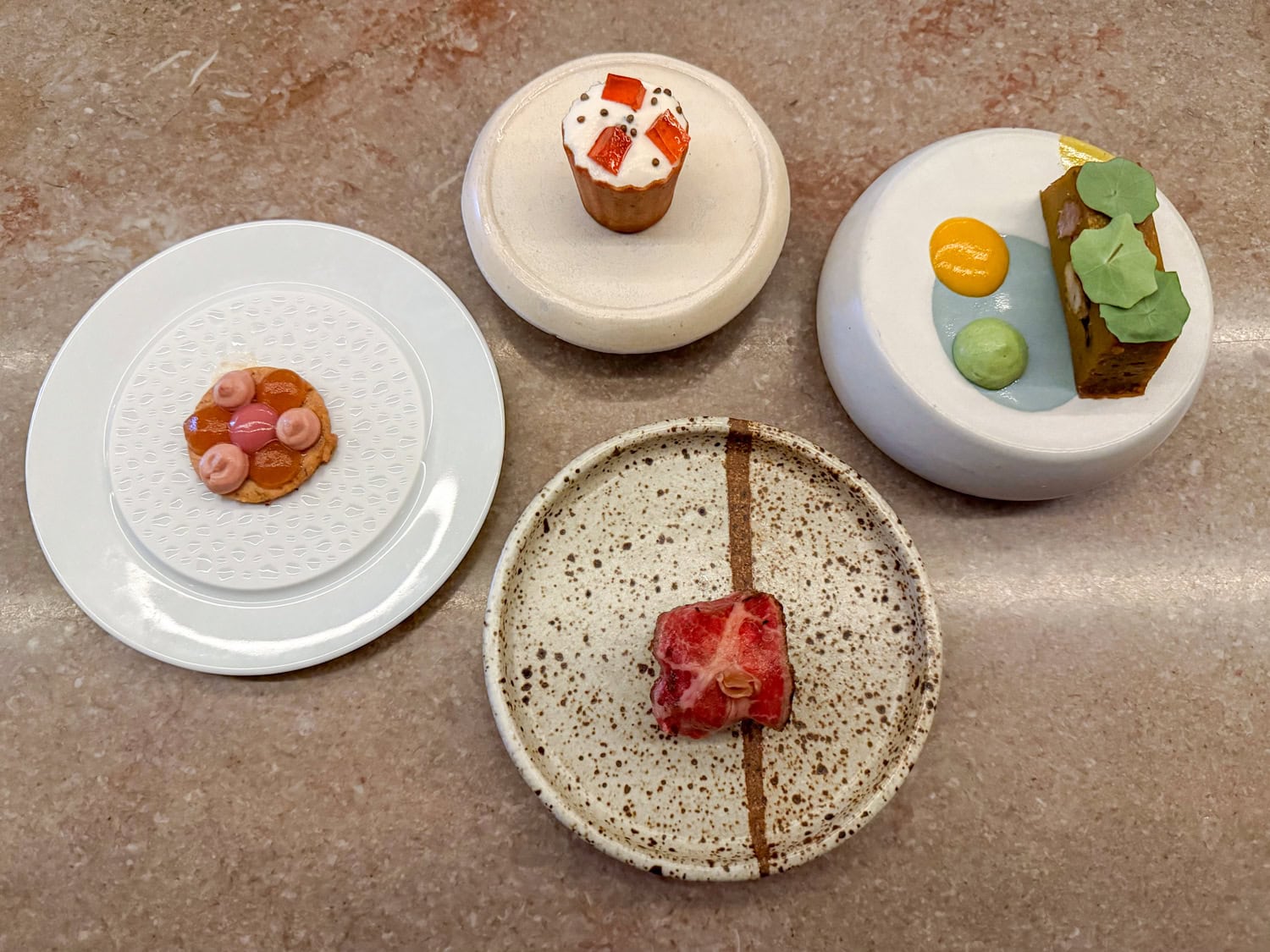 Four courses served together during the middle stretch of the tasting menu at The Catbird Seat in Nashville.