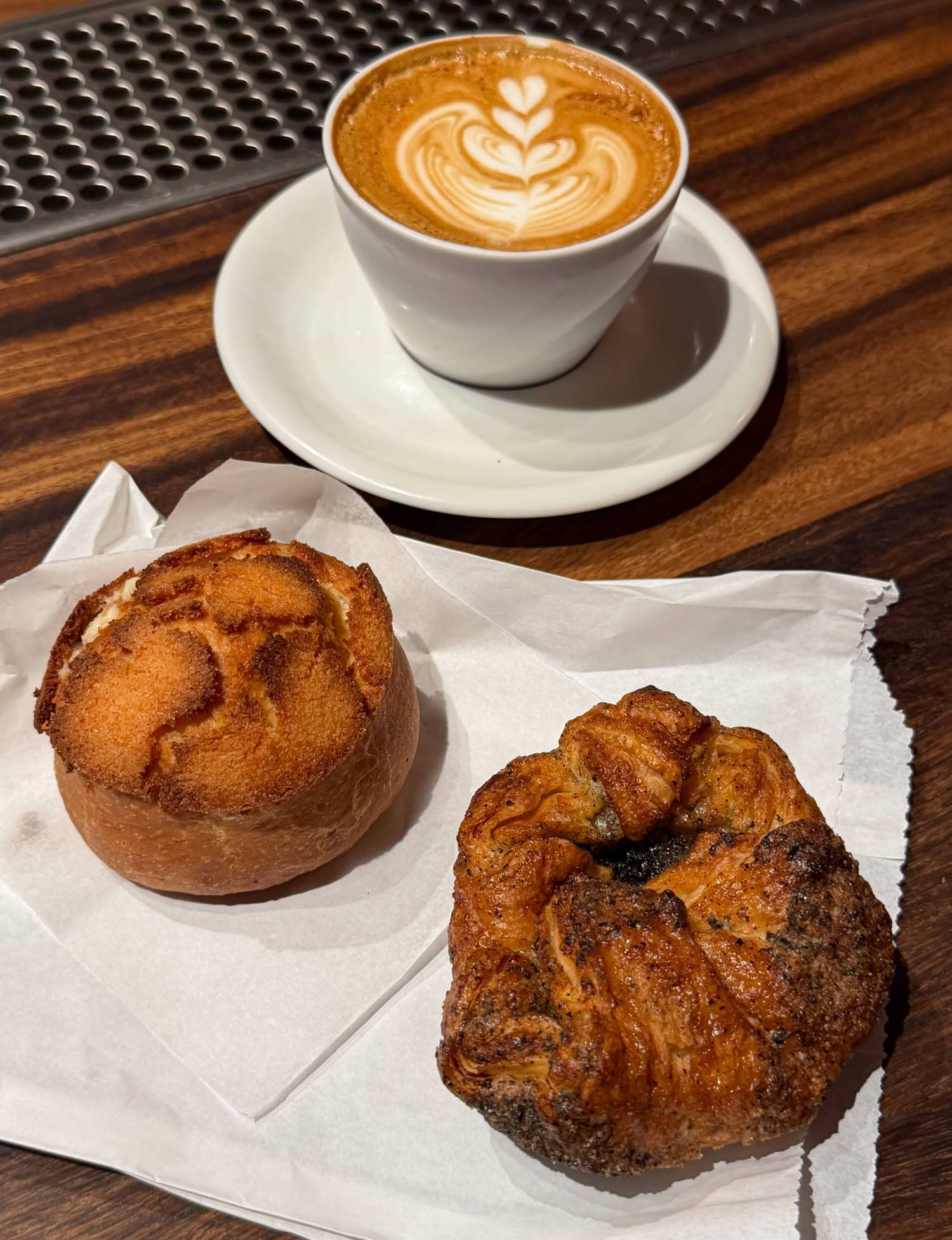 The black sesame kouign amann and a coconut cream brioche at b Patisserie, served along with a small Kona Coffee in Waikiki.
