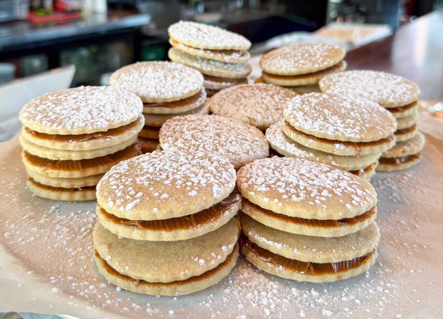 Fresh-baked alfajores dusted in powdered sugar.