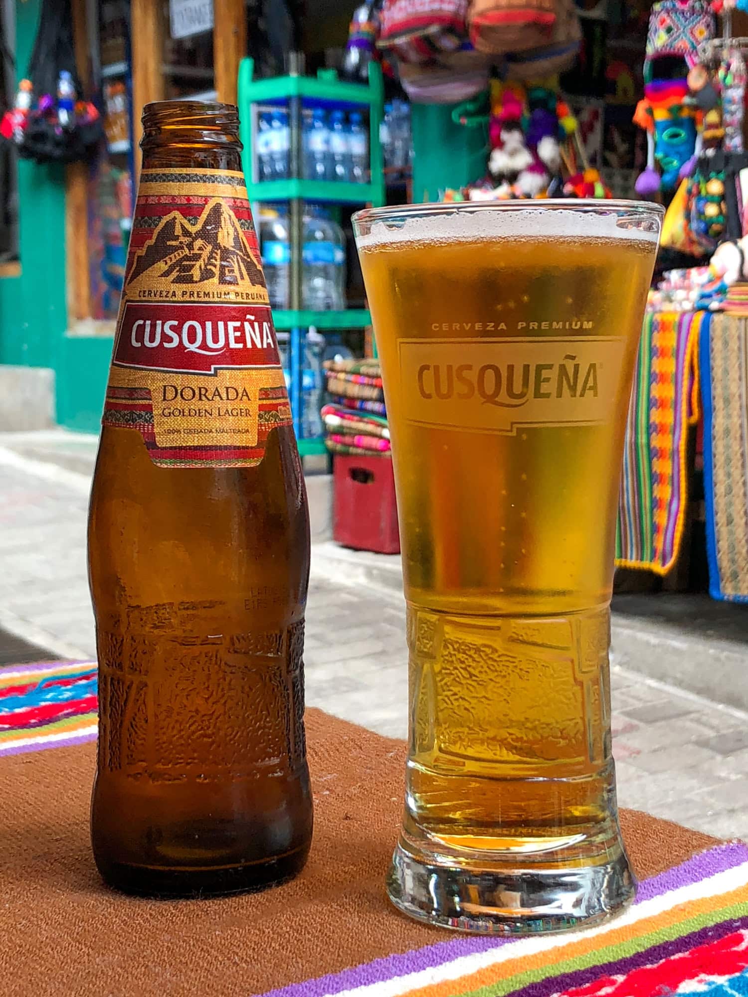 Bottle and glass of Cusqueña beer, a popular Peruvian lager from Cusco.
