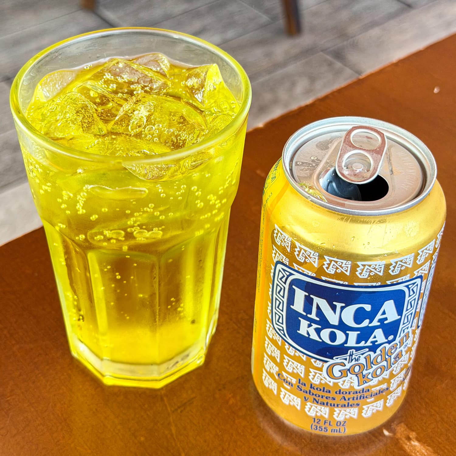 Glass of Inca Kola with can, an iconic Peruvian soft drink.