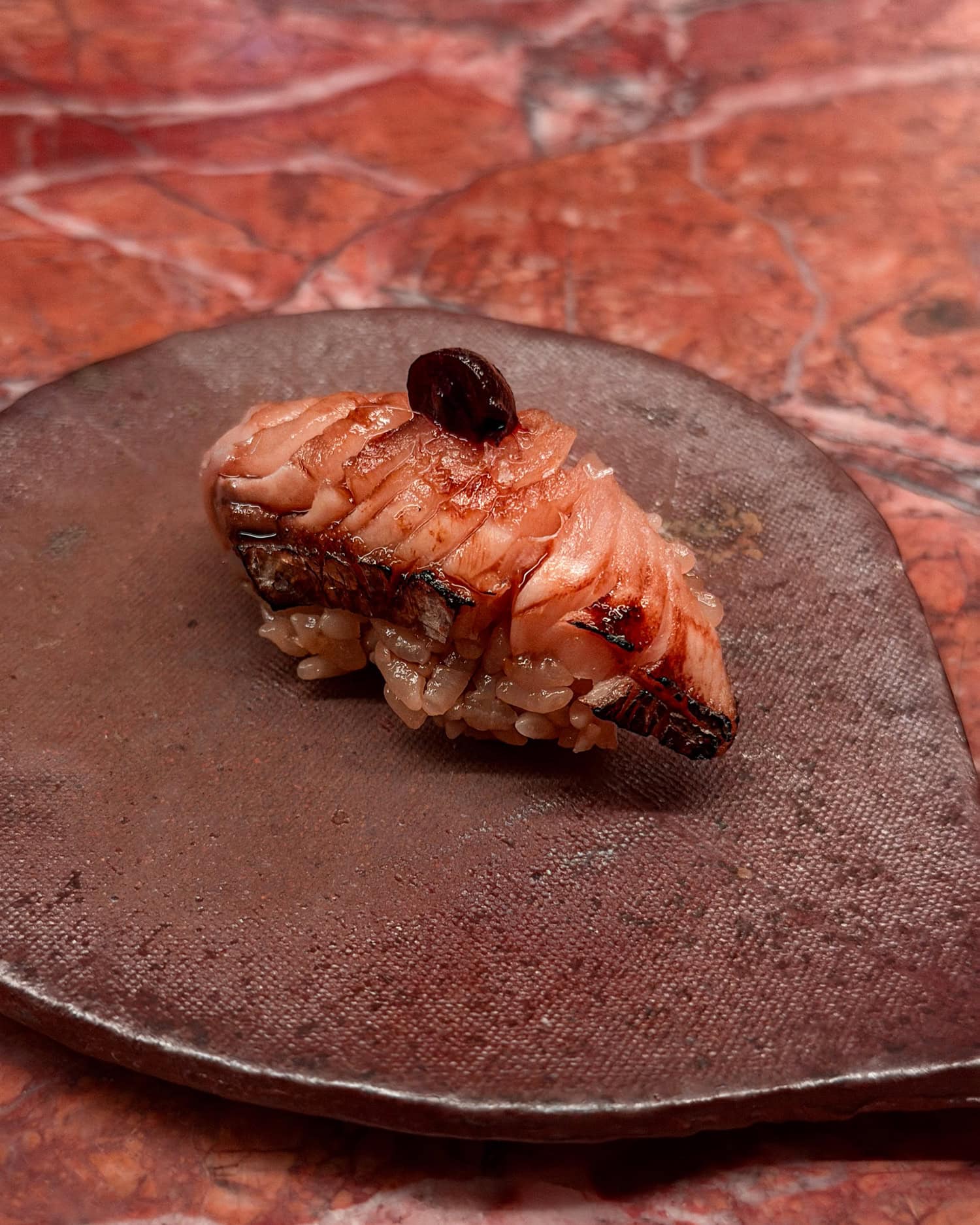 Spanish mackerel nigiri topped with blueberry at Anbā omakase in New York City