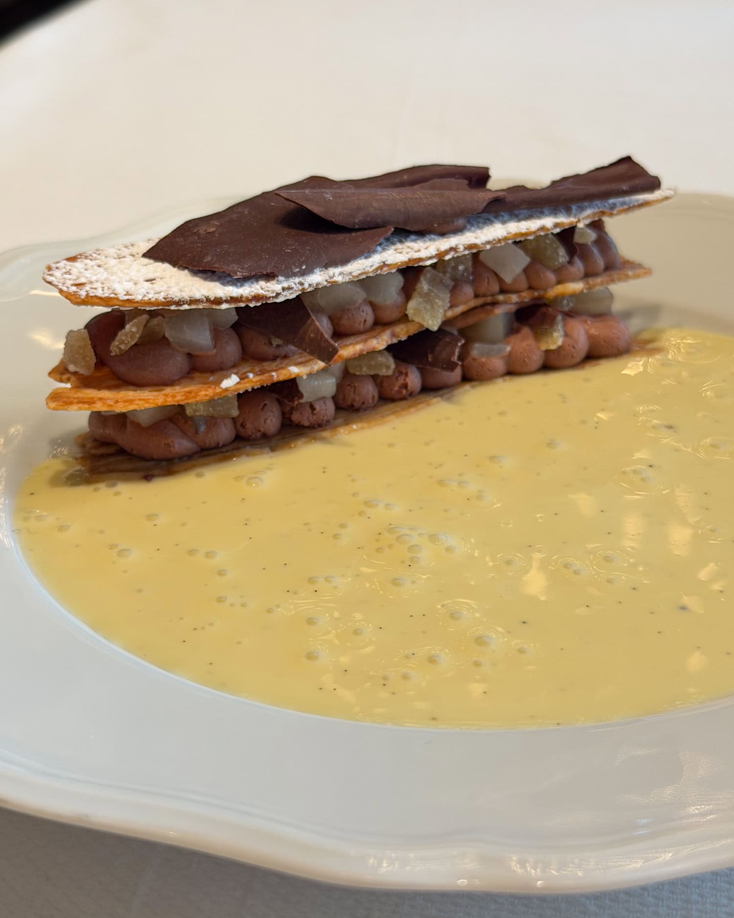 Chocolate Pear Mille Feuille dessert at Café Carmellini in New York City served with layered pastry, chocolate mousse, and vanilla sauce.