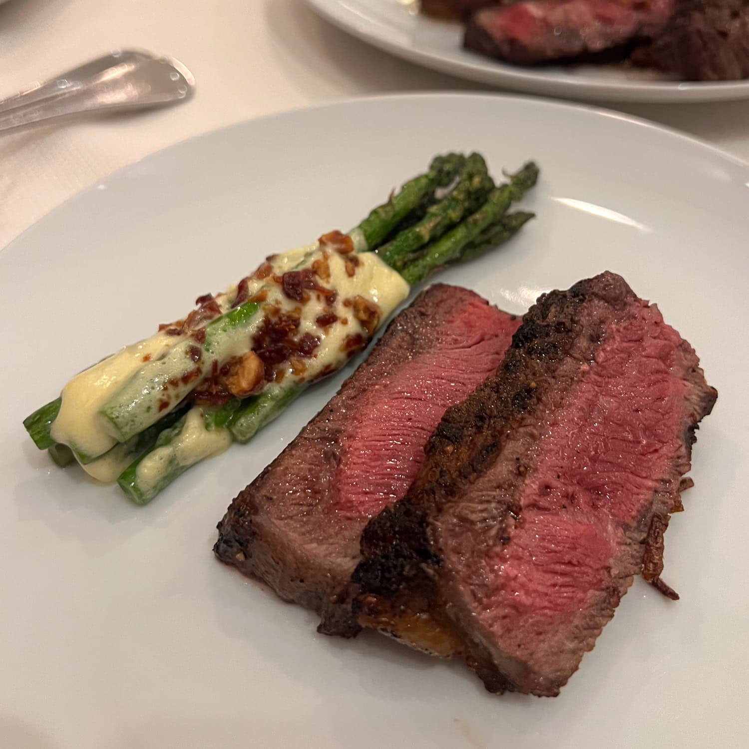 Sliced dry-aged steak with asparagus at Delmonico's steakhouse in New York City.