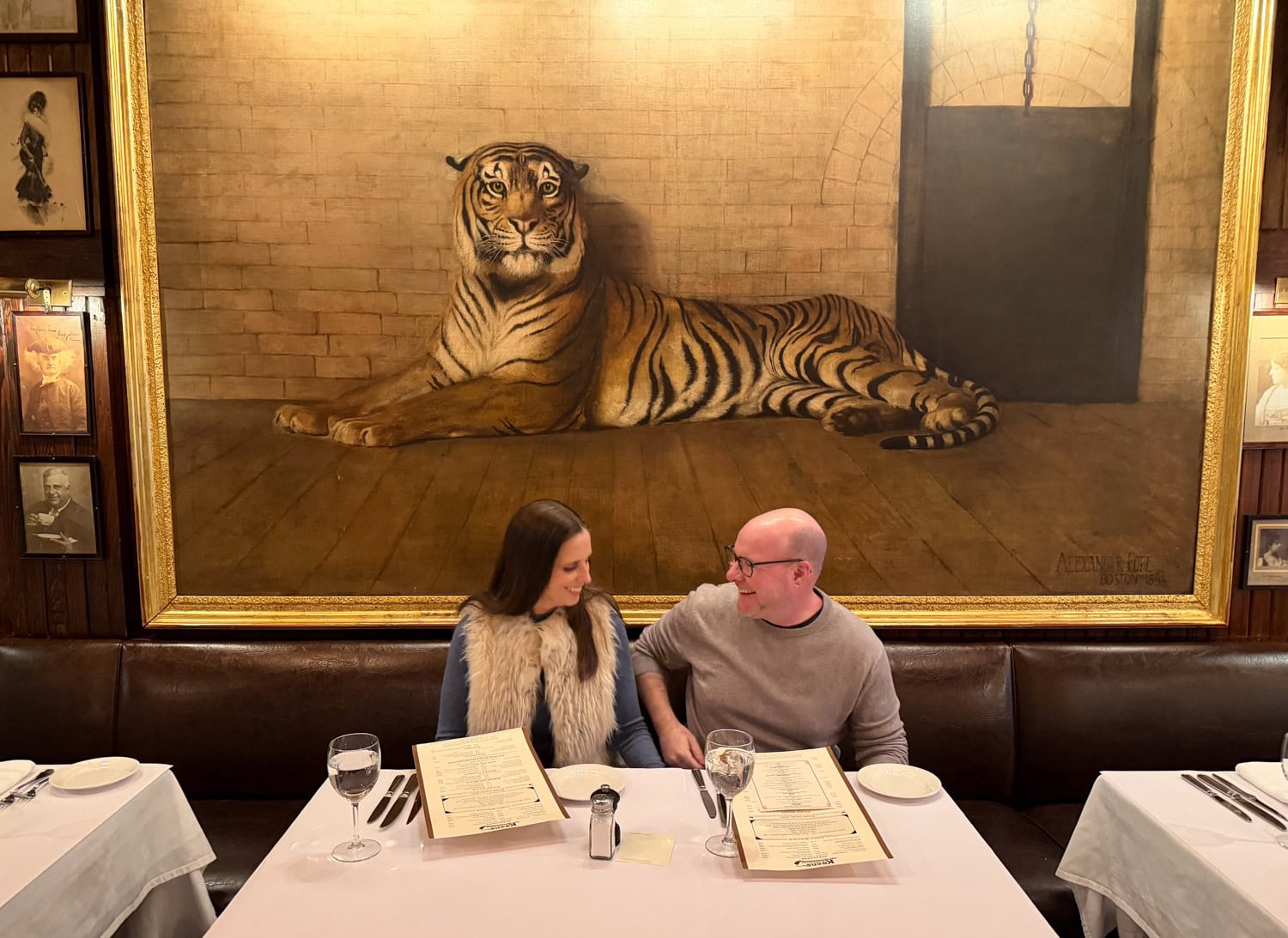 Couple seated beneath the famous tiger painting inside Keens Steakhouse in New York City.