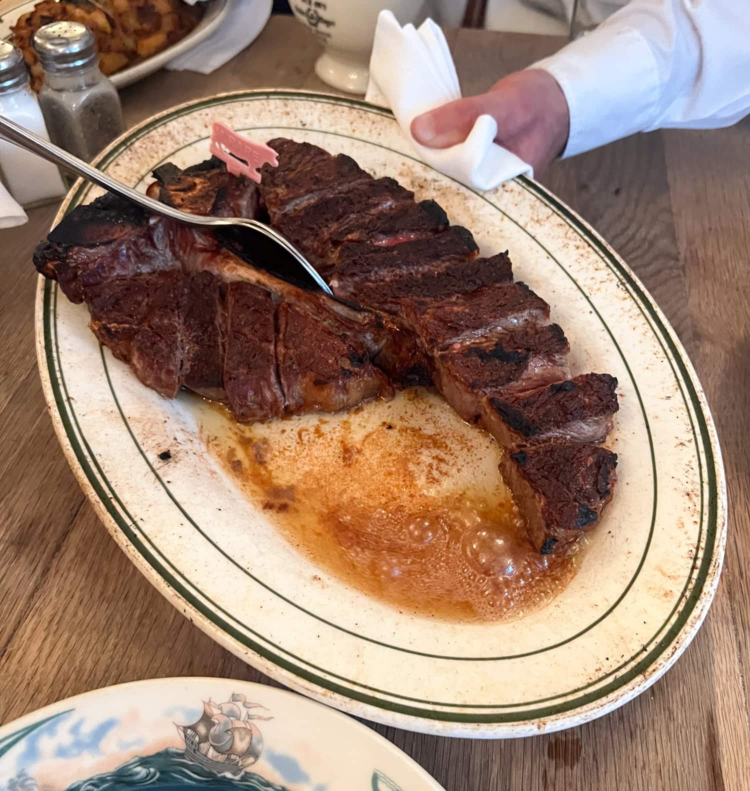 Sliced porterhouse steak served tableside at Peter Luger Steak House in Brooklyn, New York.