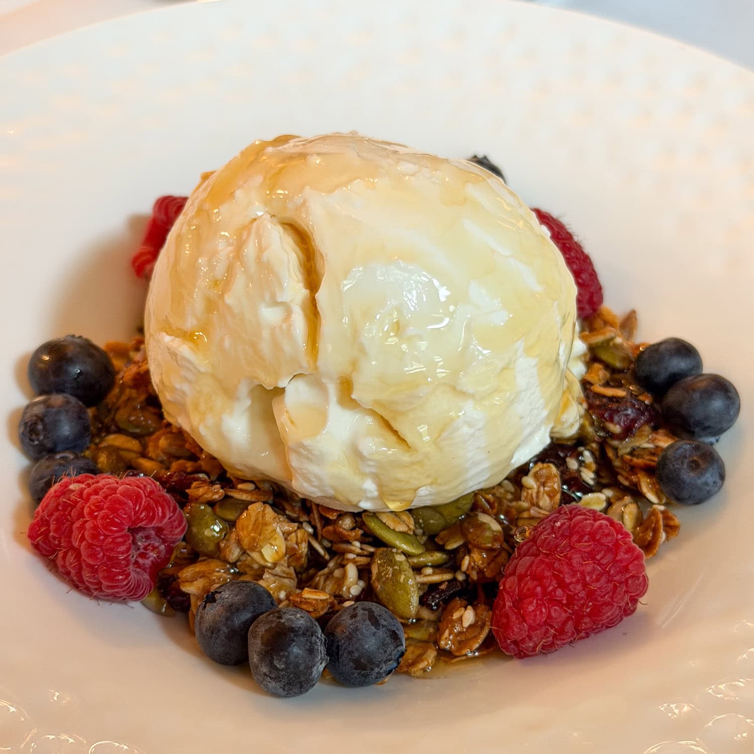 Greek yogurt with granola, blueberries, raspberries, and honey served for breakfast at Wentworth Mansion.