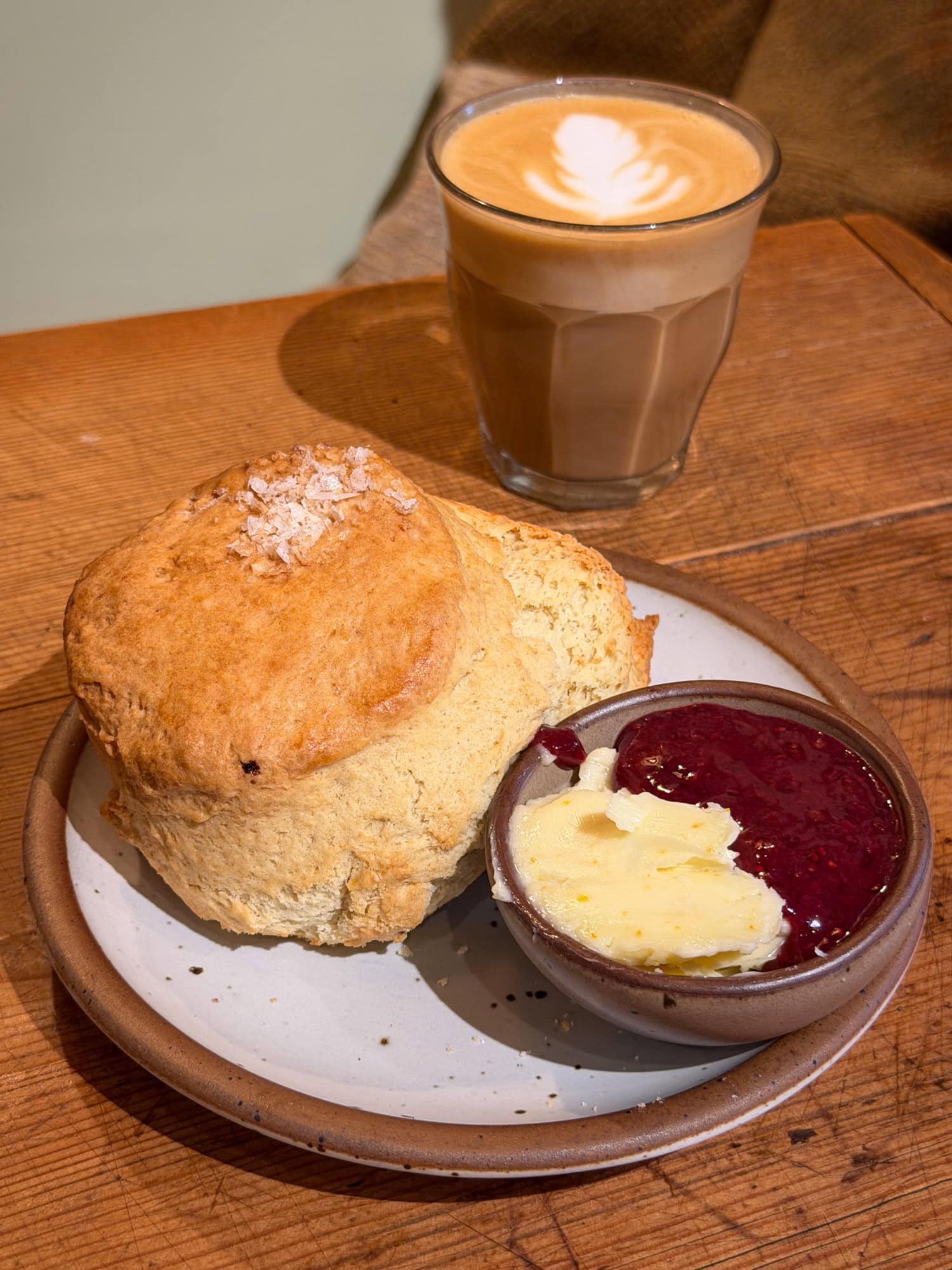 Biscuit with strawberry compote and butter alongside a cortado at Harken Cafe