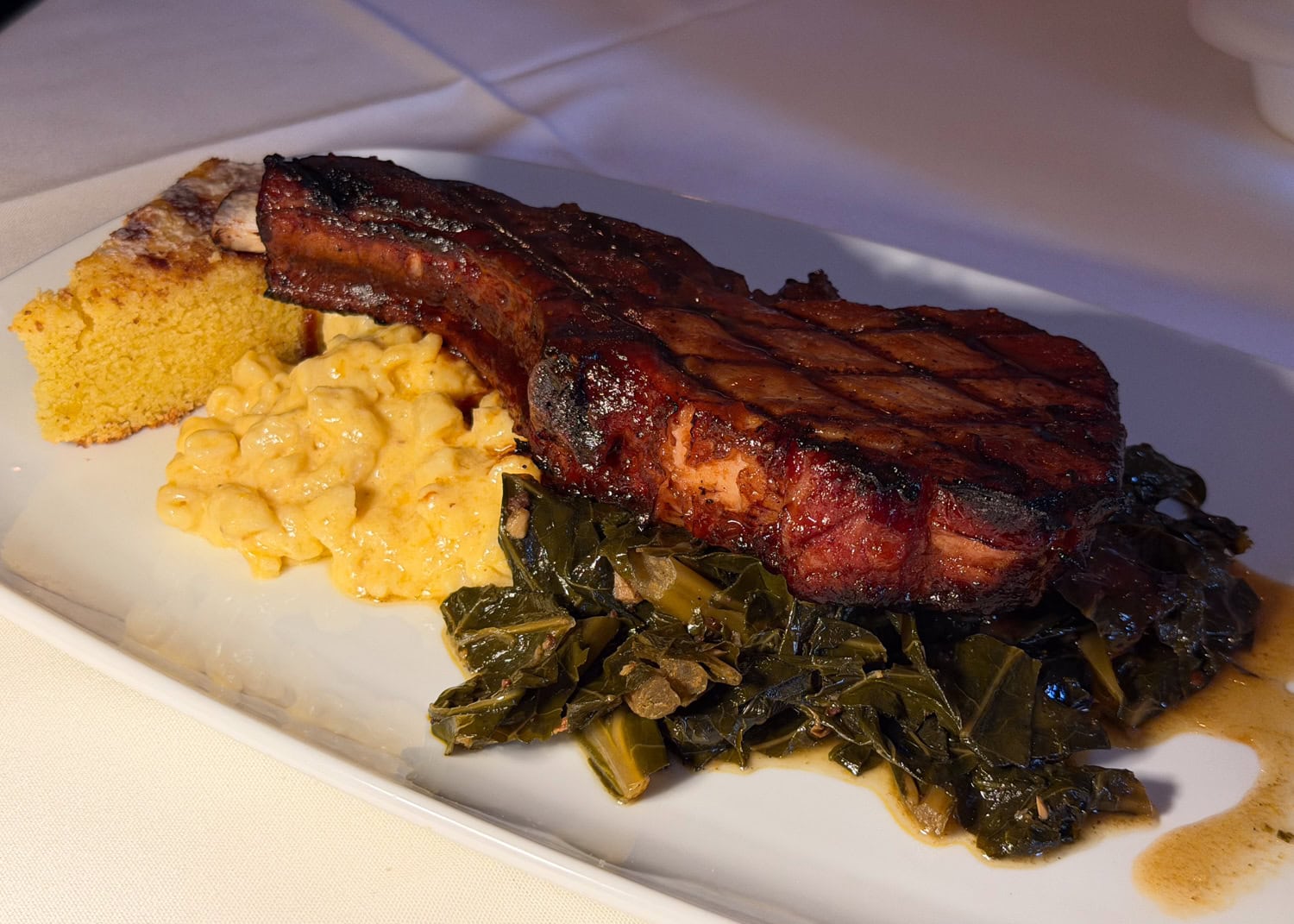 BBQ smoked pork chop with mac and cheese, collard greens, and cornbread at Magnolias