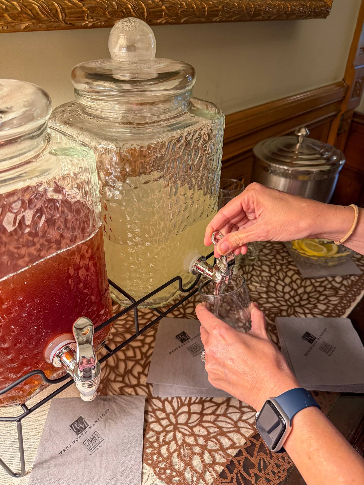 Guest pouring complimentary lemonade from a beverage station