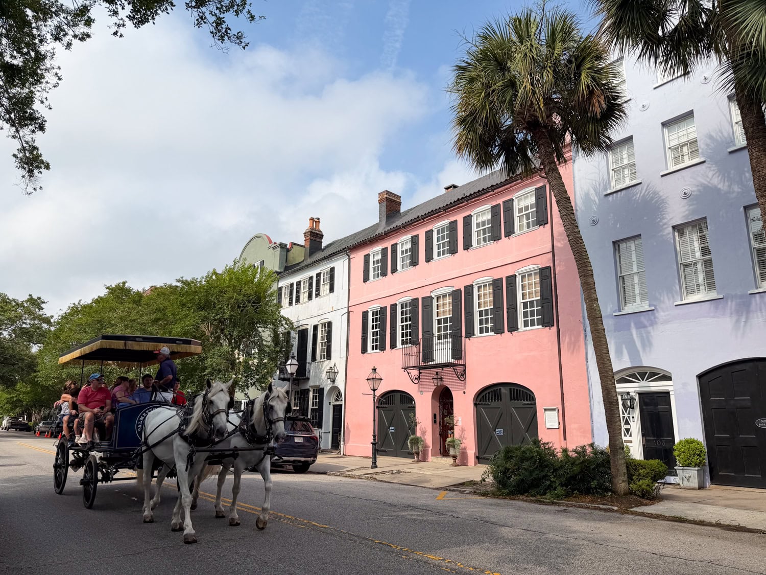 Horse carriage passing colorful historic homes along Rainbow Row in Charleston, South Carolina