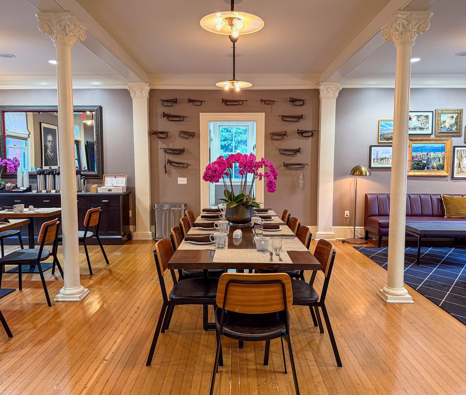 Dining room at the Inn at the Presidio with a long table, orchids, and historic decor