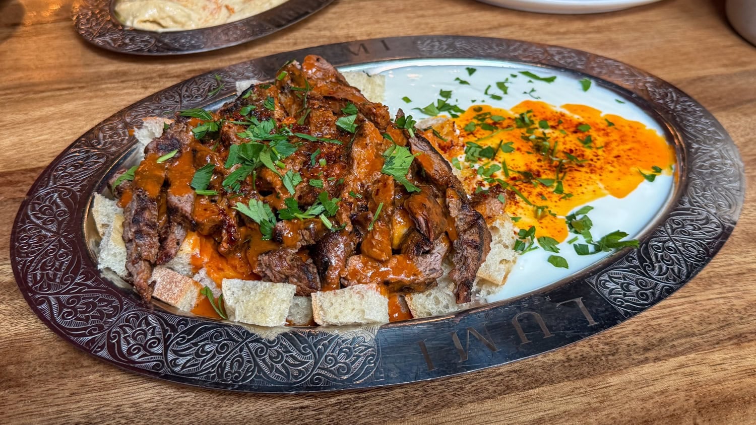 Iskender with sliced meat, bread, yogurt and tomato-butter sauce at Lumi Restaurant in Minneapolis