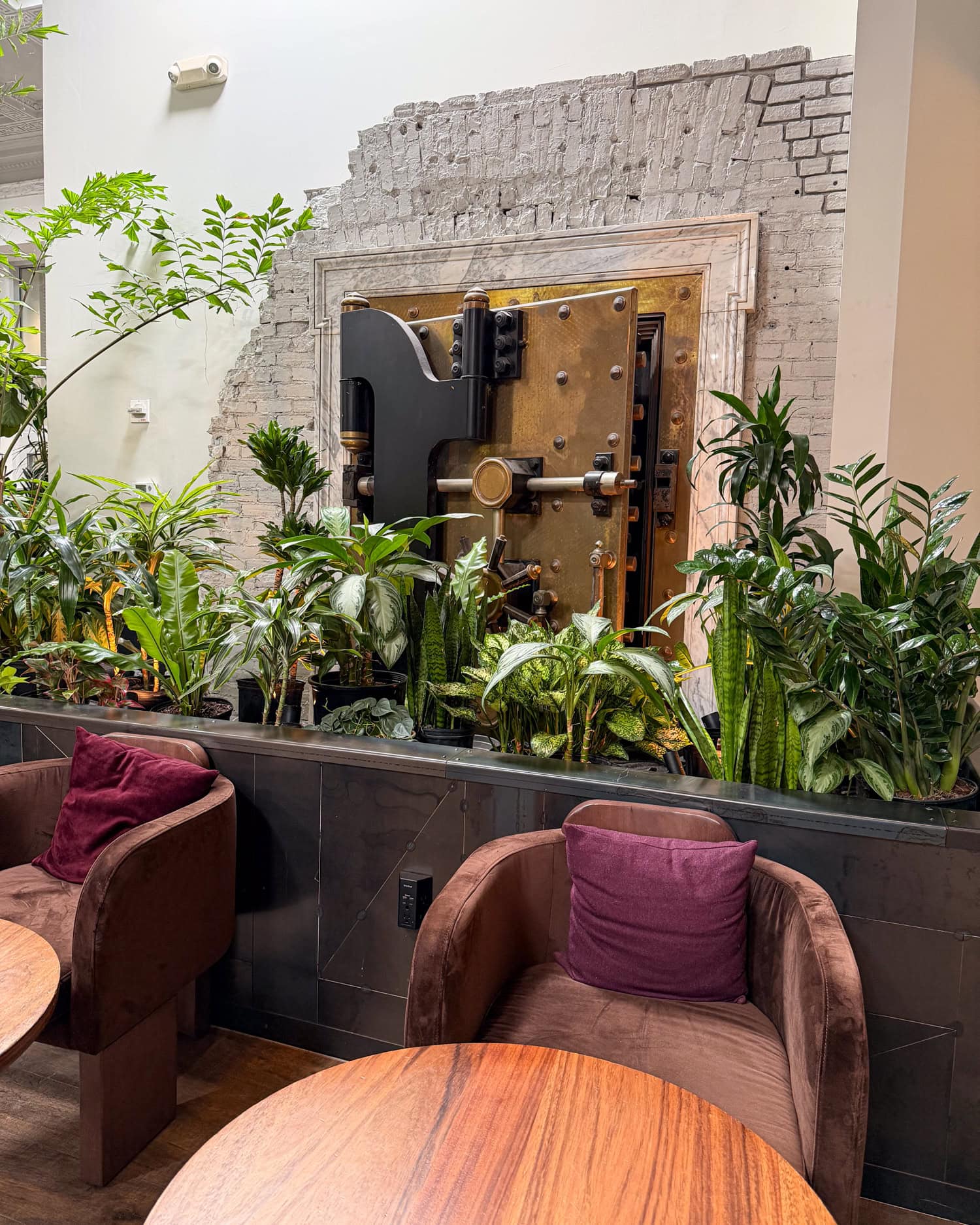 Original bank vault door surrounded by plants inside Spyhouse Coffee in Minneapolis